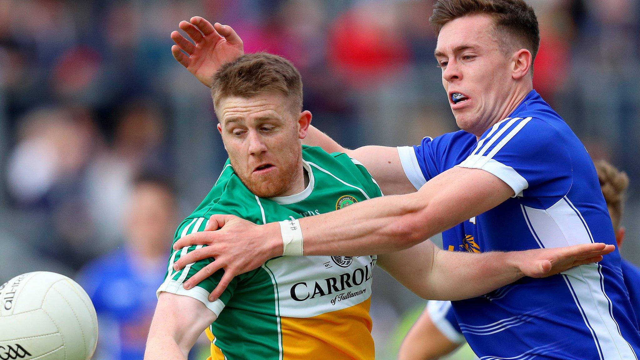 Offaly's Nigel Dunne shields the ball from Cavan forward Dara McVeety