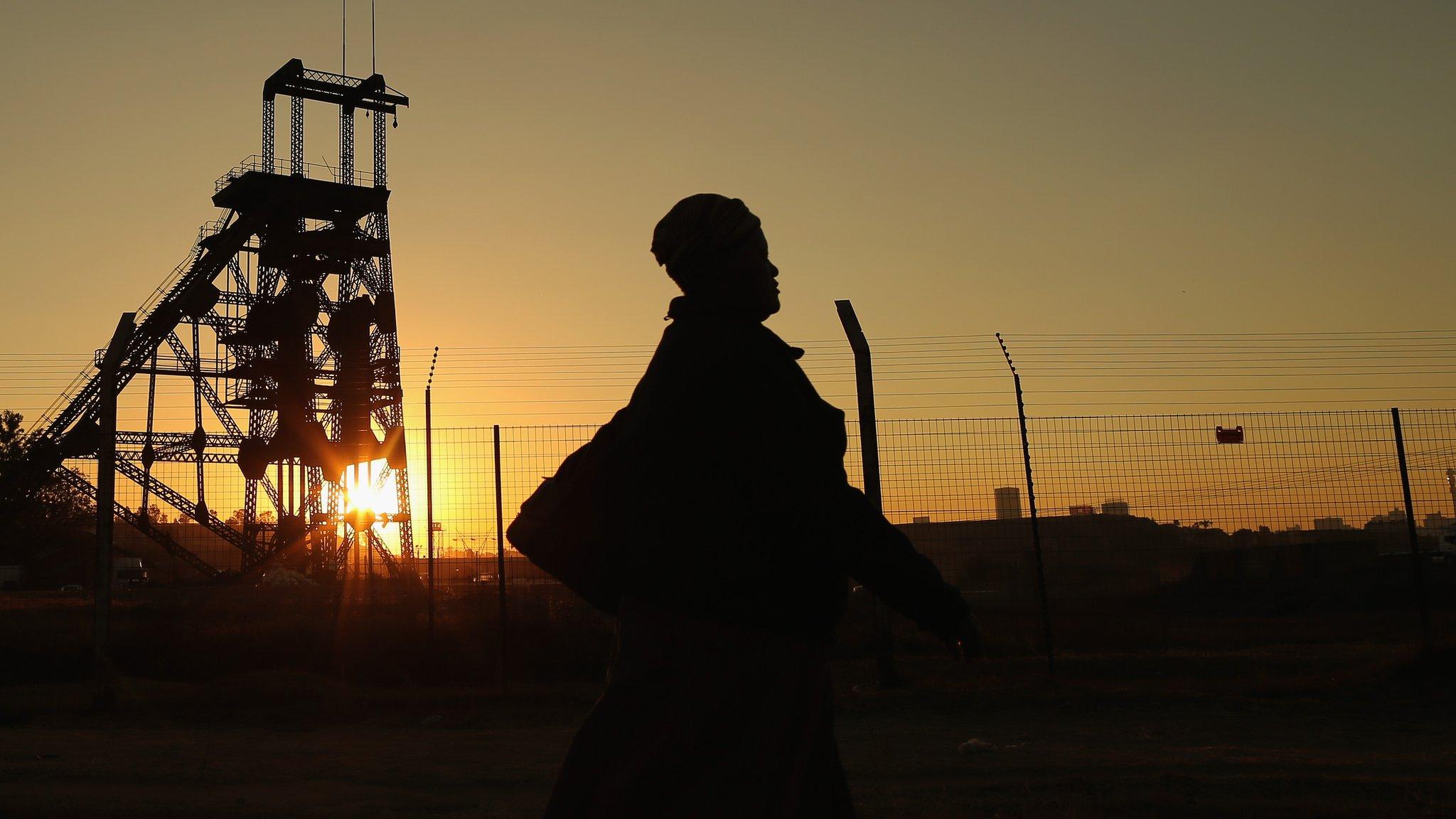 Lady walking past mine in South Africa