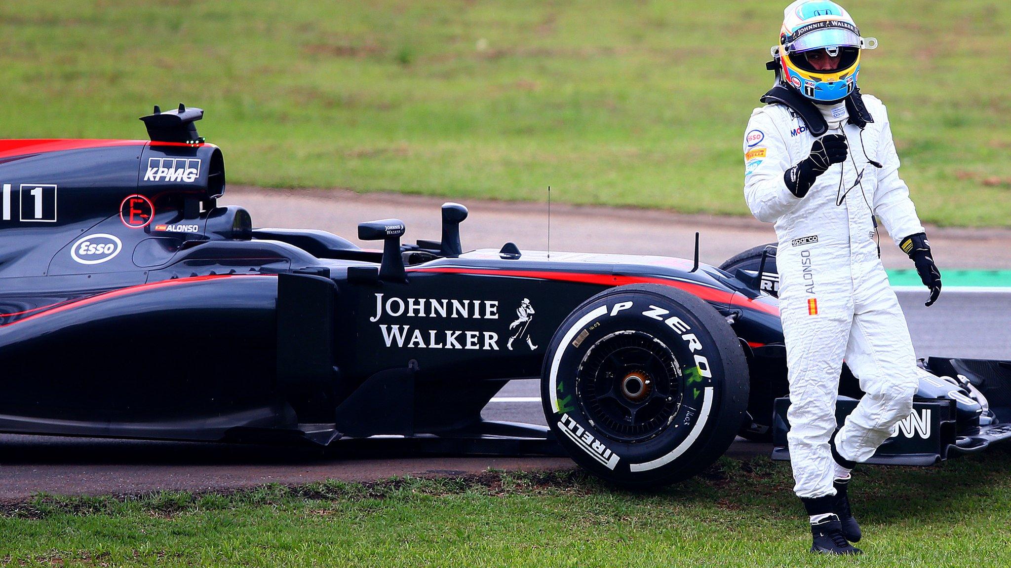 Fernando Alonso steps out of his car after retiring in the Brazilian Grand Prix