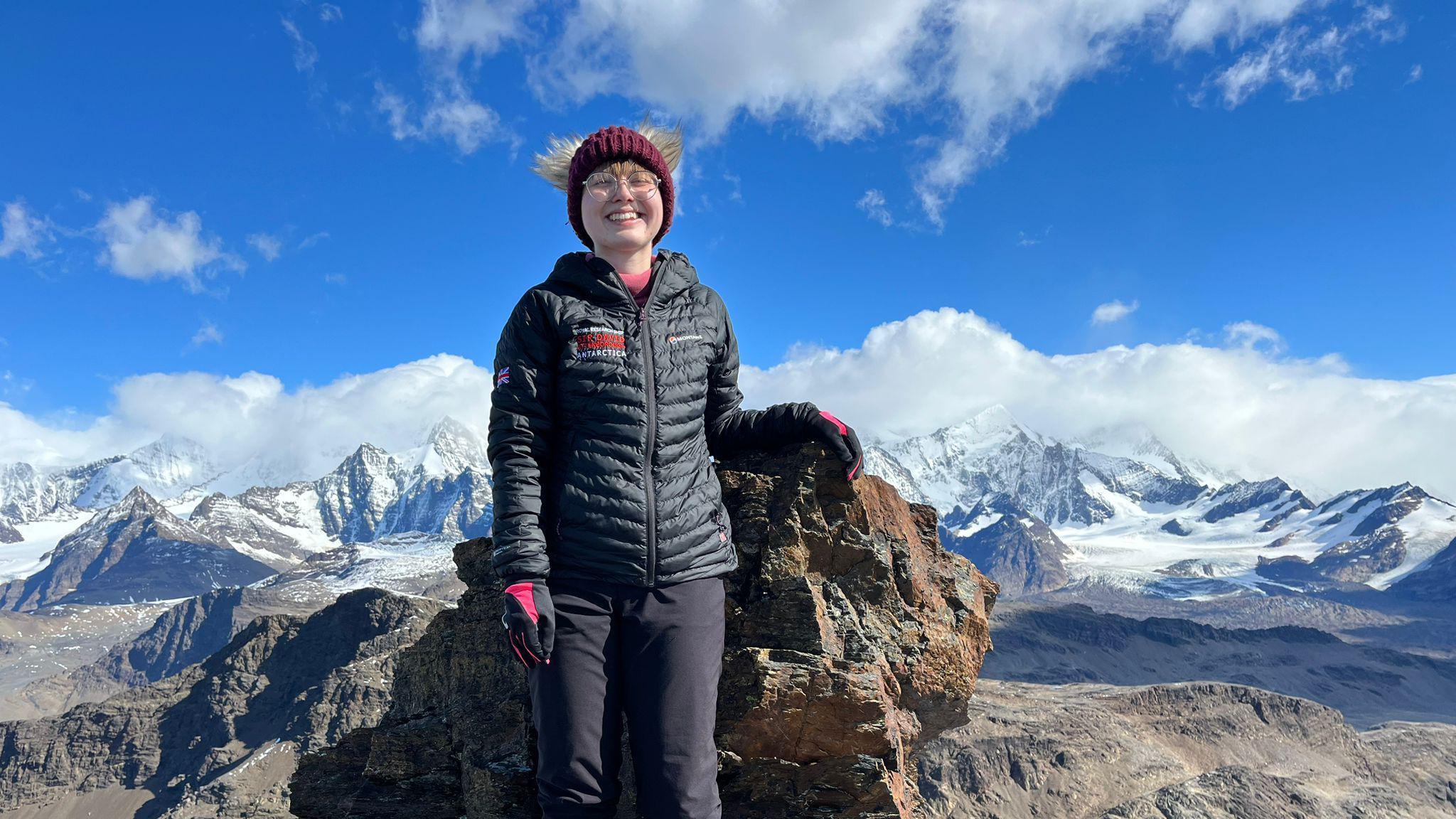 Aoife McKenna wearing a winter hat and glasses with snowy hills behind her