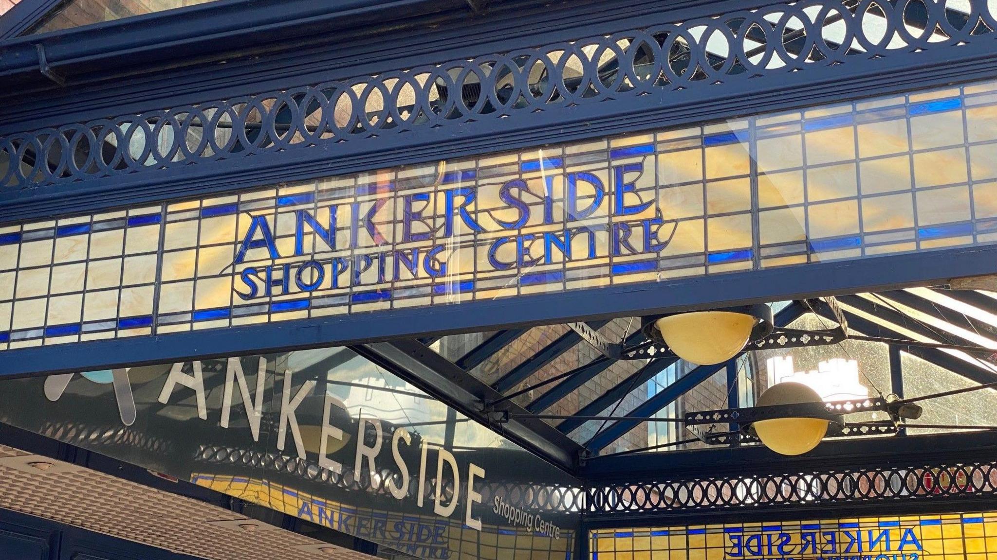 A traditional canopy above the entrance to the Ankerside shopping centre in Tamworth. It has stained glass sides which contain the shopping centre's name in blue writing.