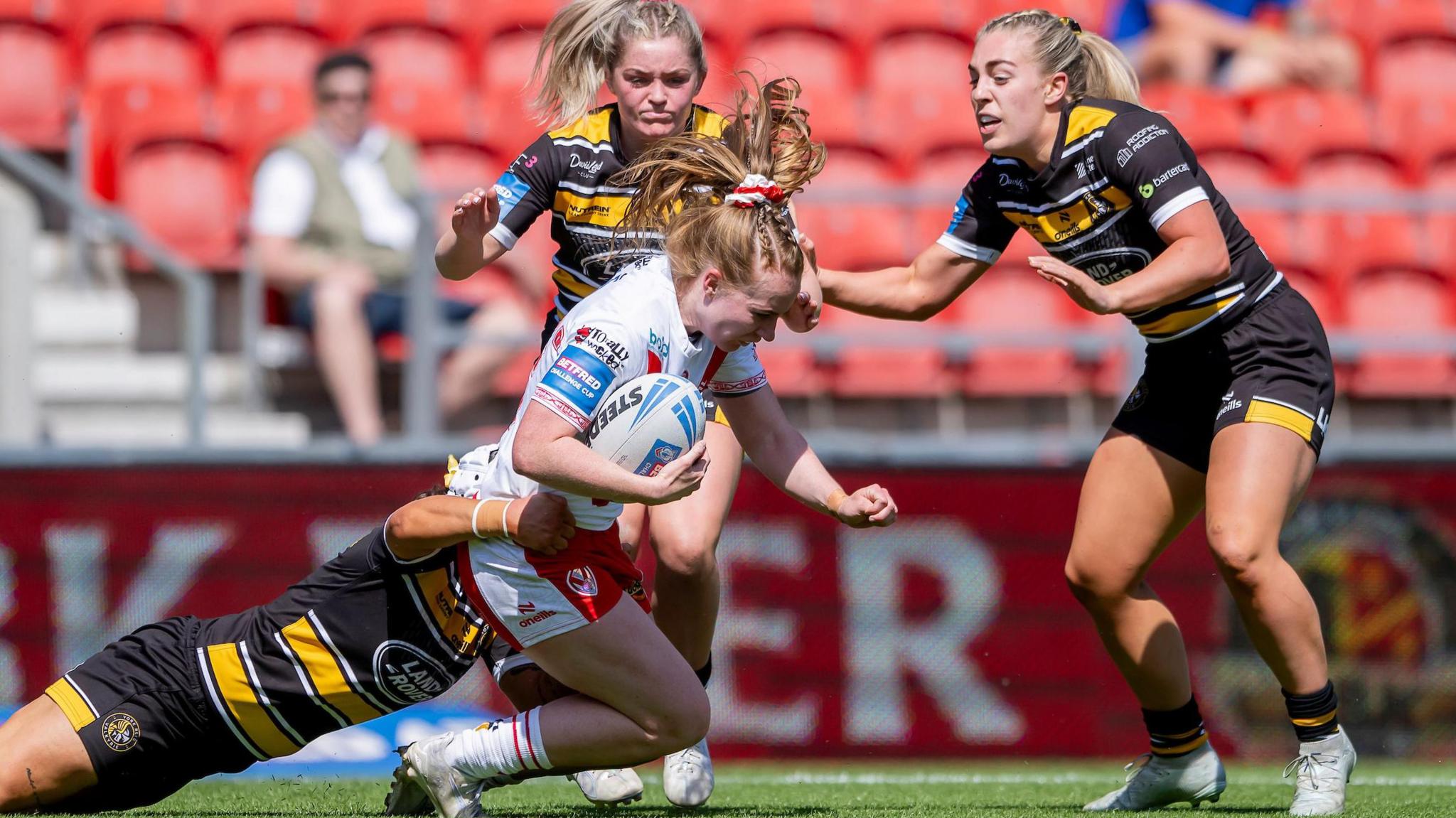 Dani McGifford is tackled from behind as she runs forward with the ball for St Helens against York