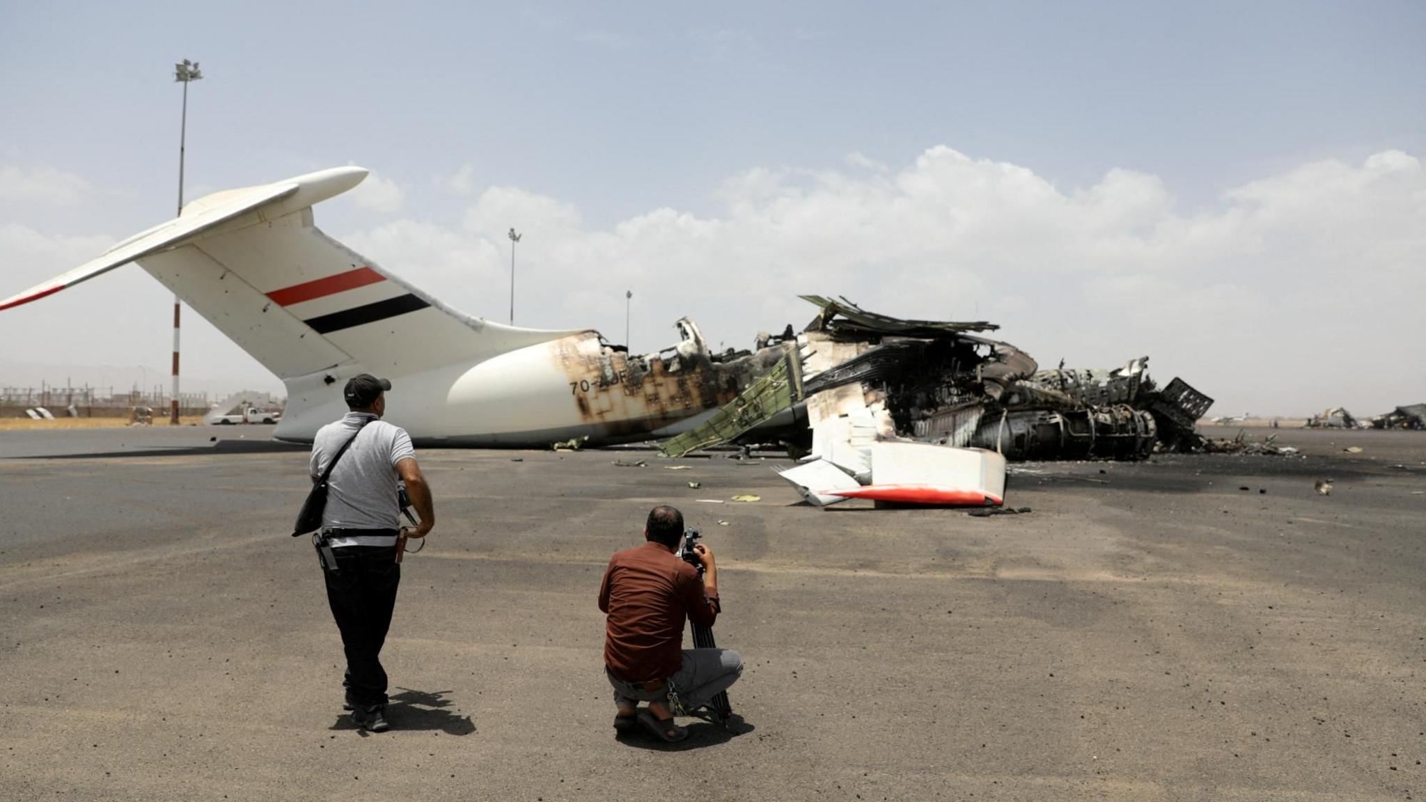 Journalists take photos of a destroyed plane at Sanaa International Airport following an Israeli air strike, in Sanaa, Yemen (7 May 2025)