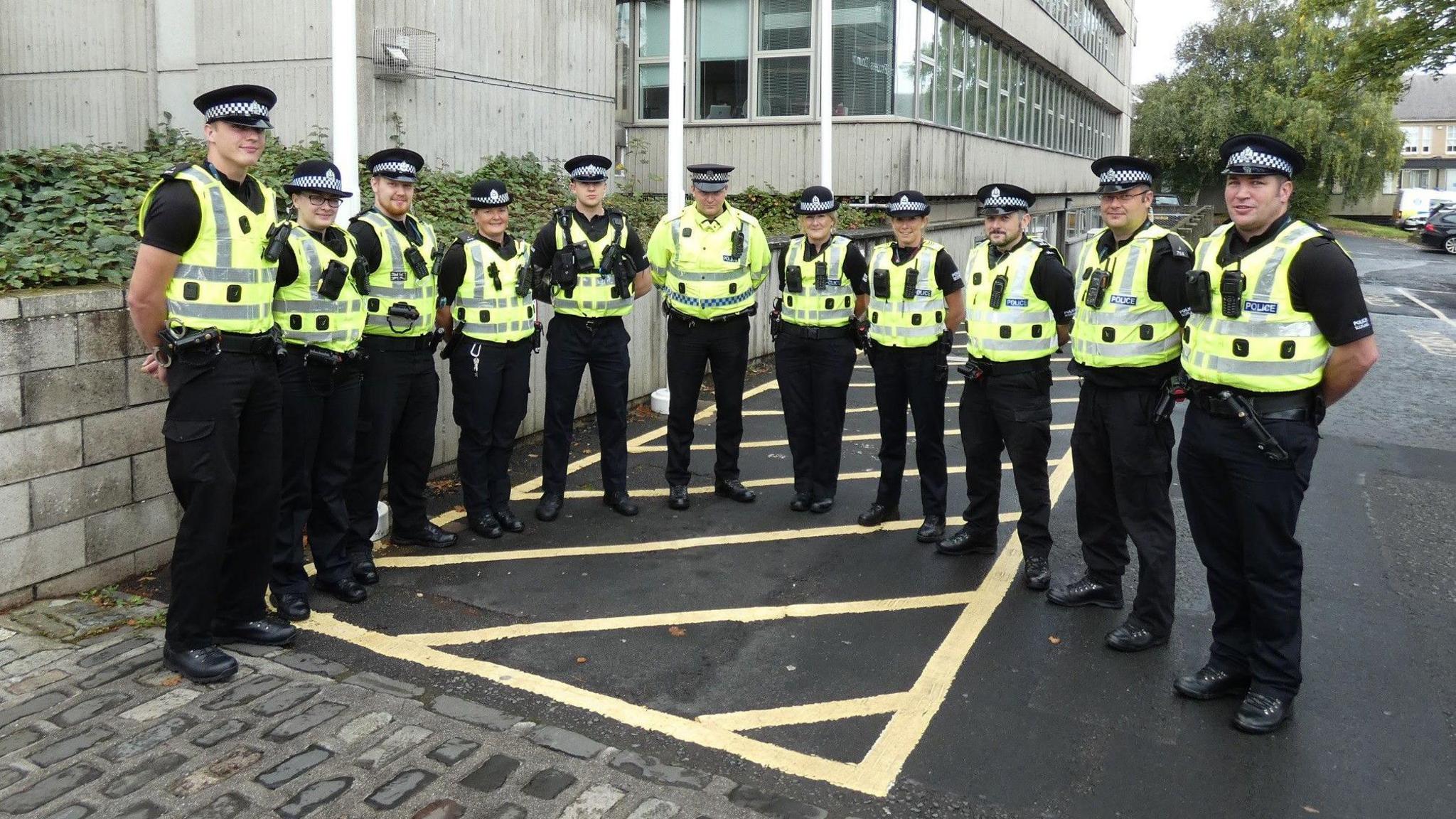 A group of police officers in high visibility tops and black uniforms stands outside Scottish Borders Council's headquarters