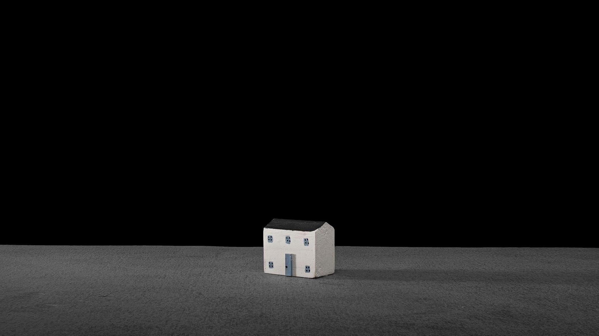 Another example of Mr Daly's photography. This one features a small white house with light blue windows and doors. The floor is grey and the backdrop is black.