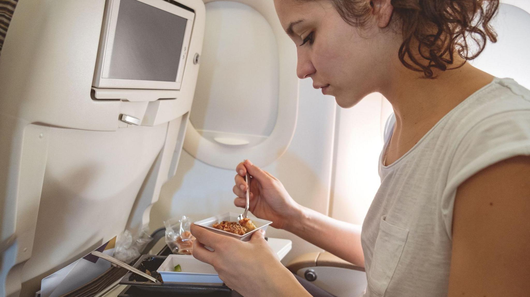 Woman eating on a plane