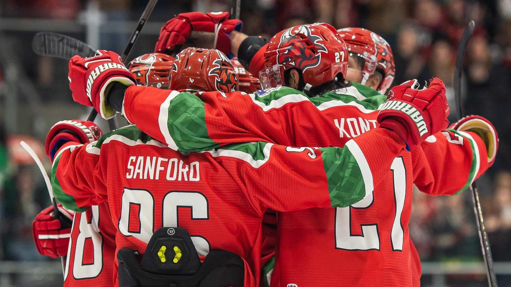 Cardiff Devils in red kit players celebrate in a huddle