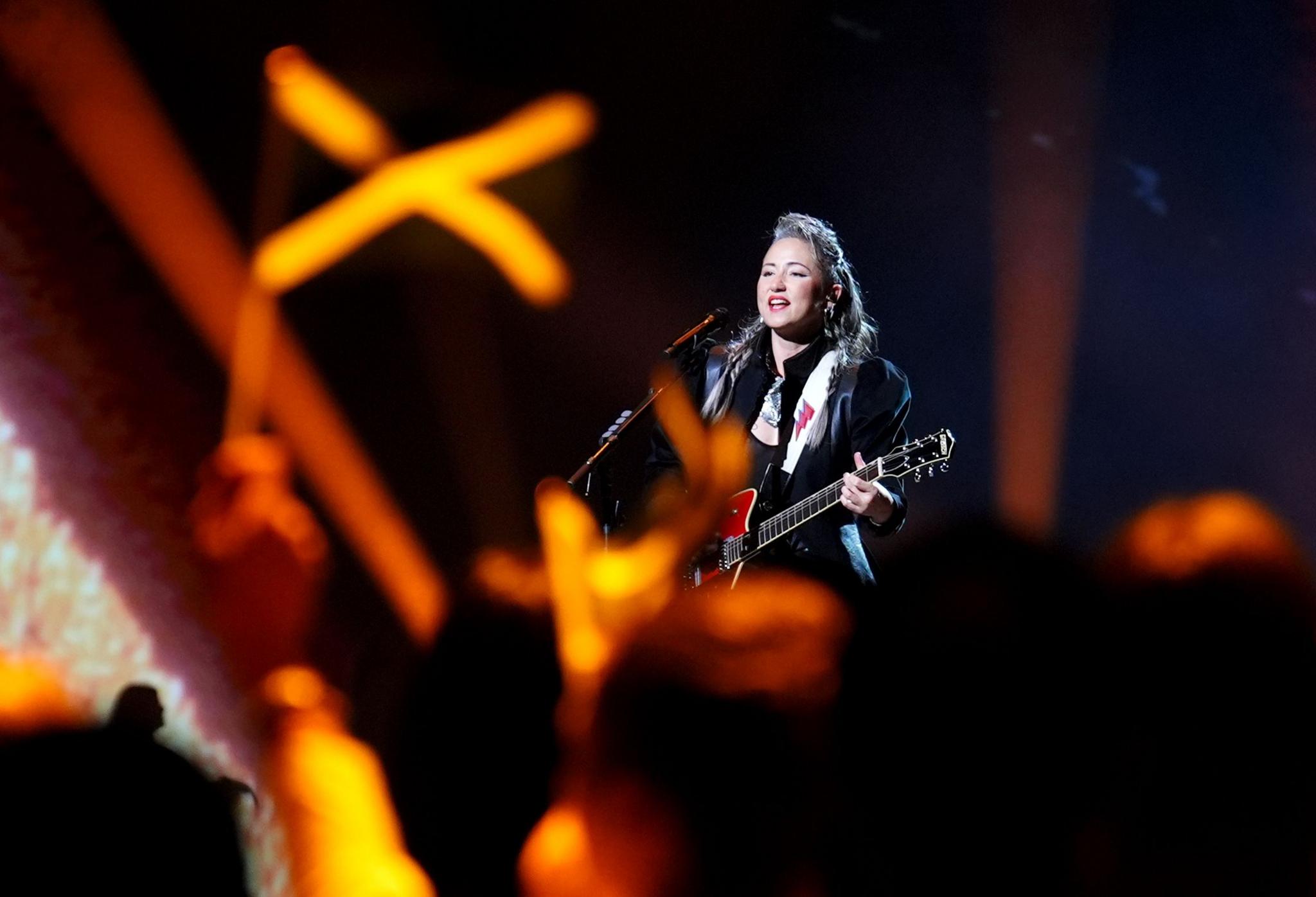 Singer songwriter KT Tunstall performing with a guitar on stage.