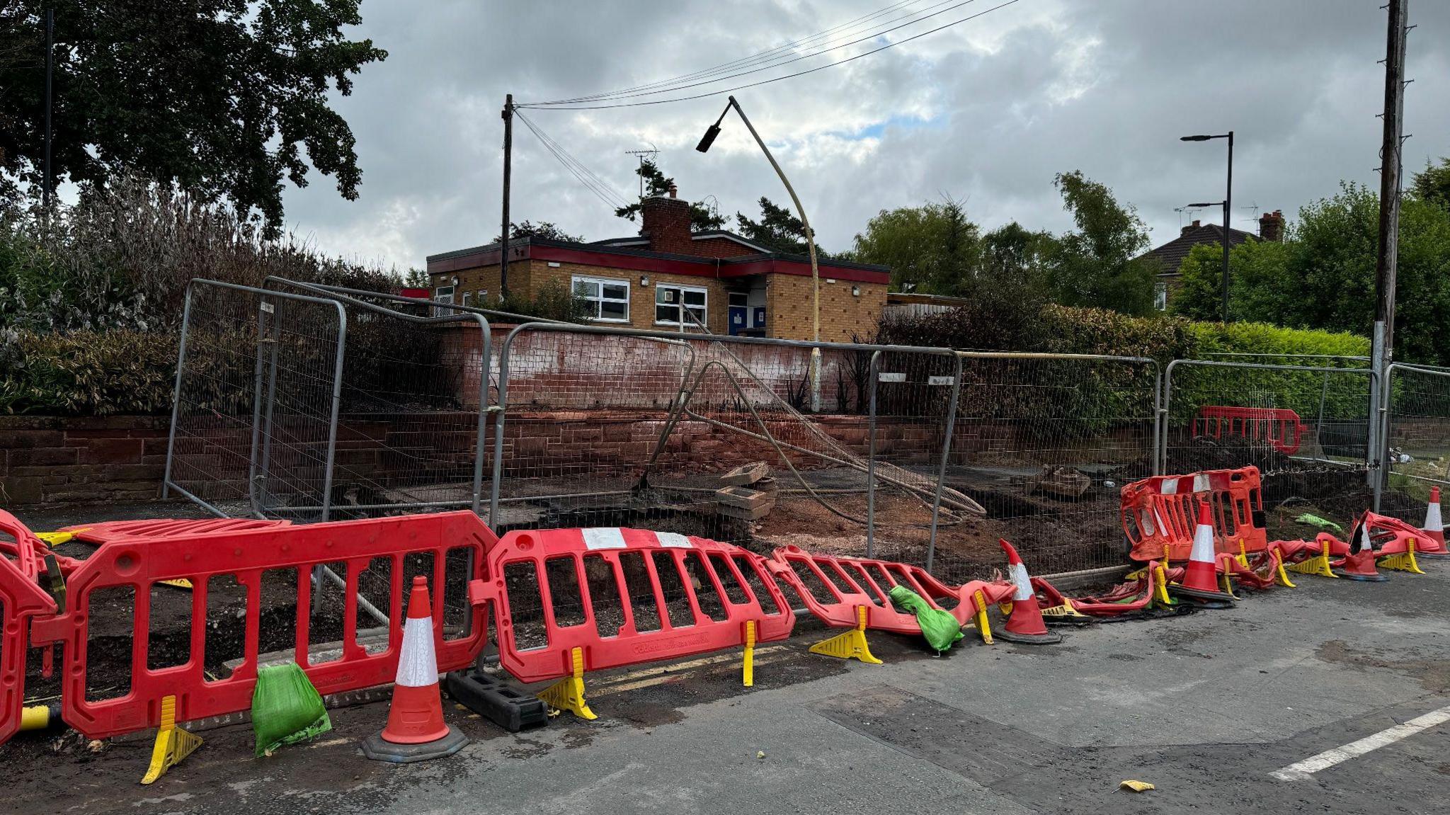 The scene of the gas fire leak on Dee Banks with metal and red plastic fencing