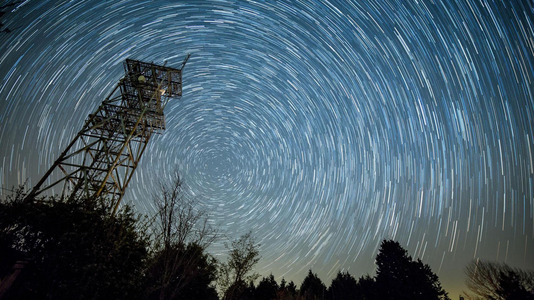 流星让夜空中充满了树木和下面的电力塔。