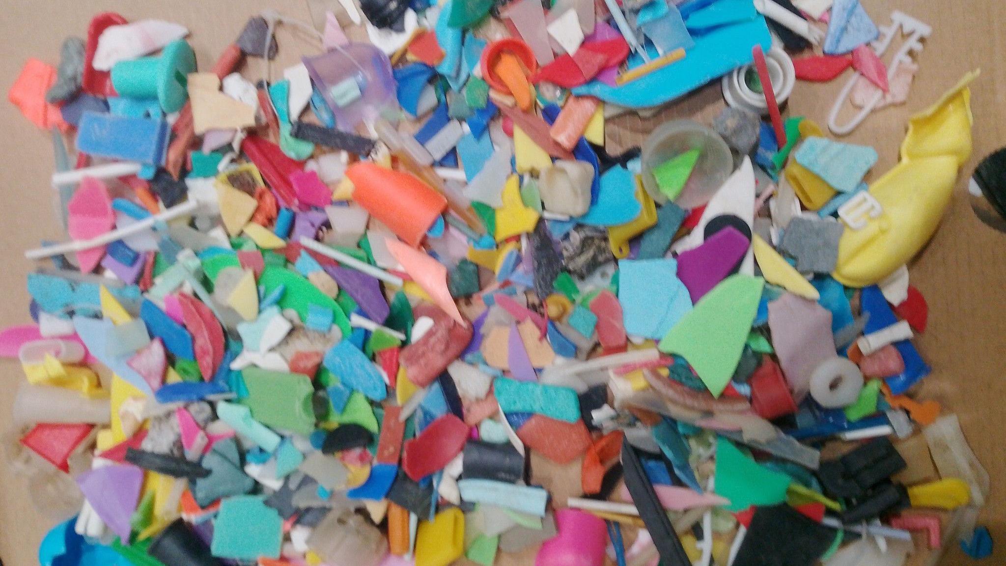A pile of tiny broken fragments of brightly coloured plastic.