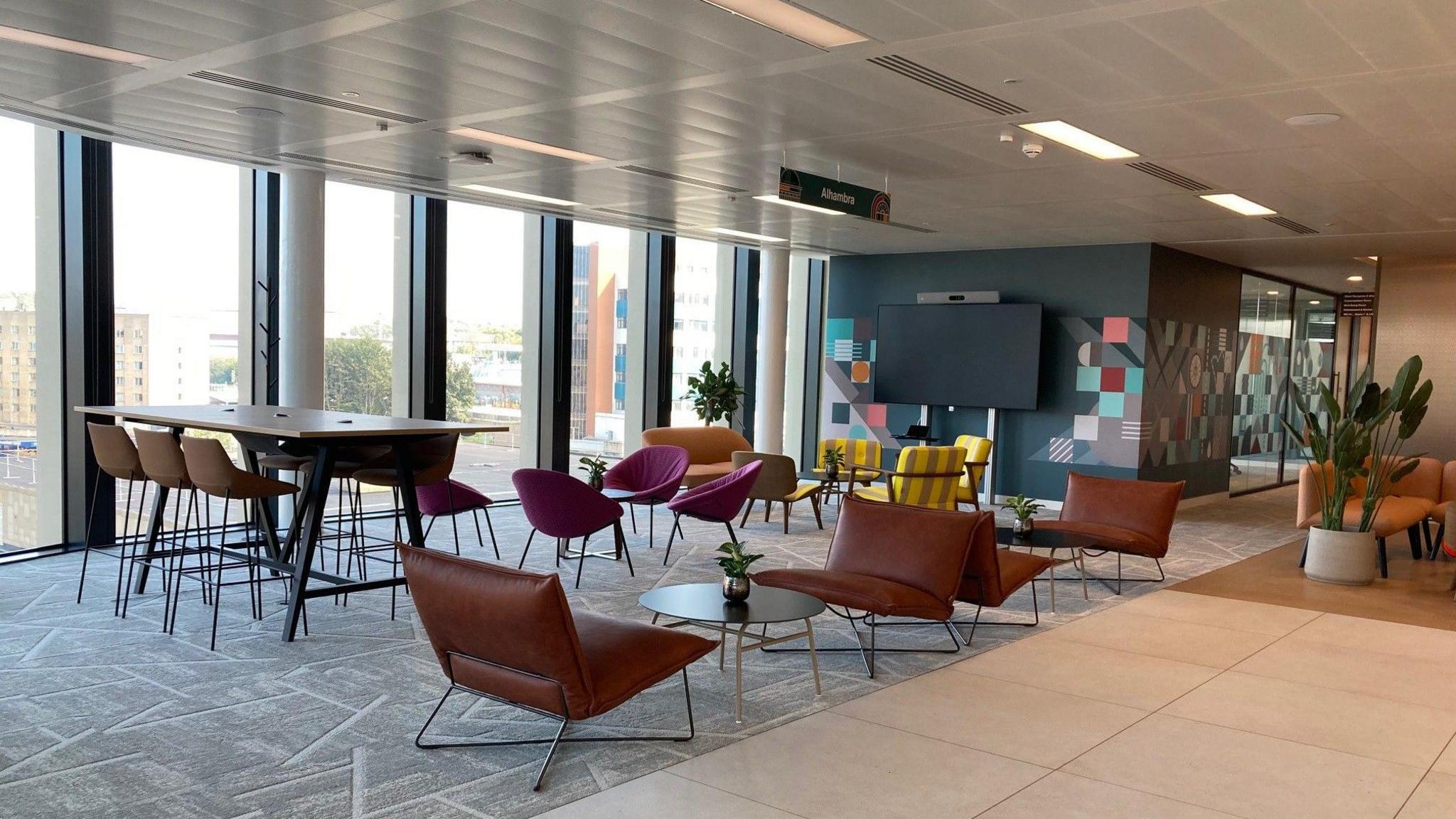 A shot of leather and fabric designer seating and floor-to-ceiling windows inside one of the floors in the new office block 