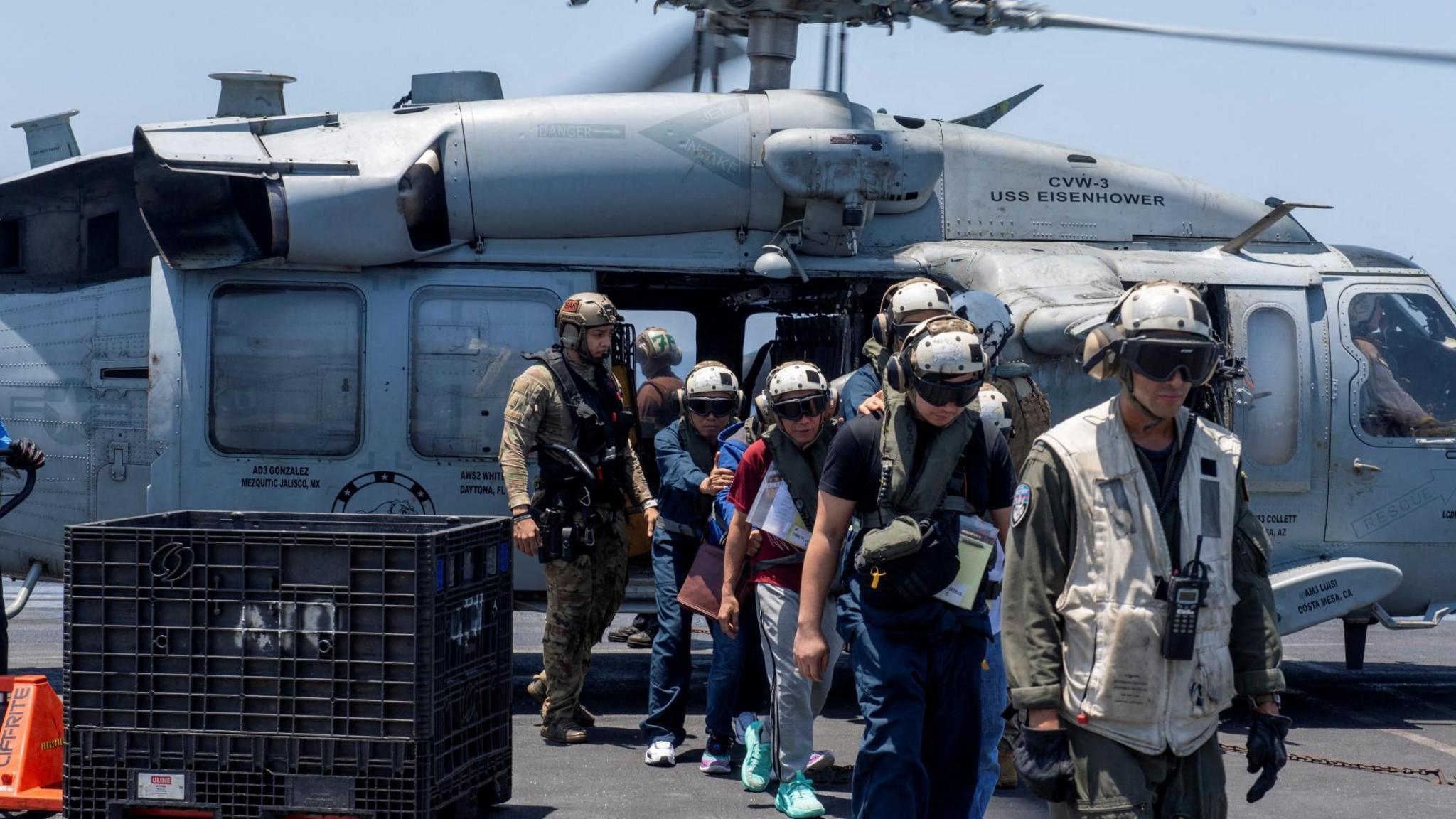 The crew of the cargo ship Tutor get off a US Navy helicopter after being abandoning ship in the Red Sea (15 June 2024)