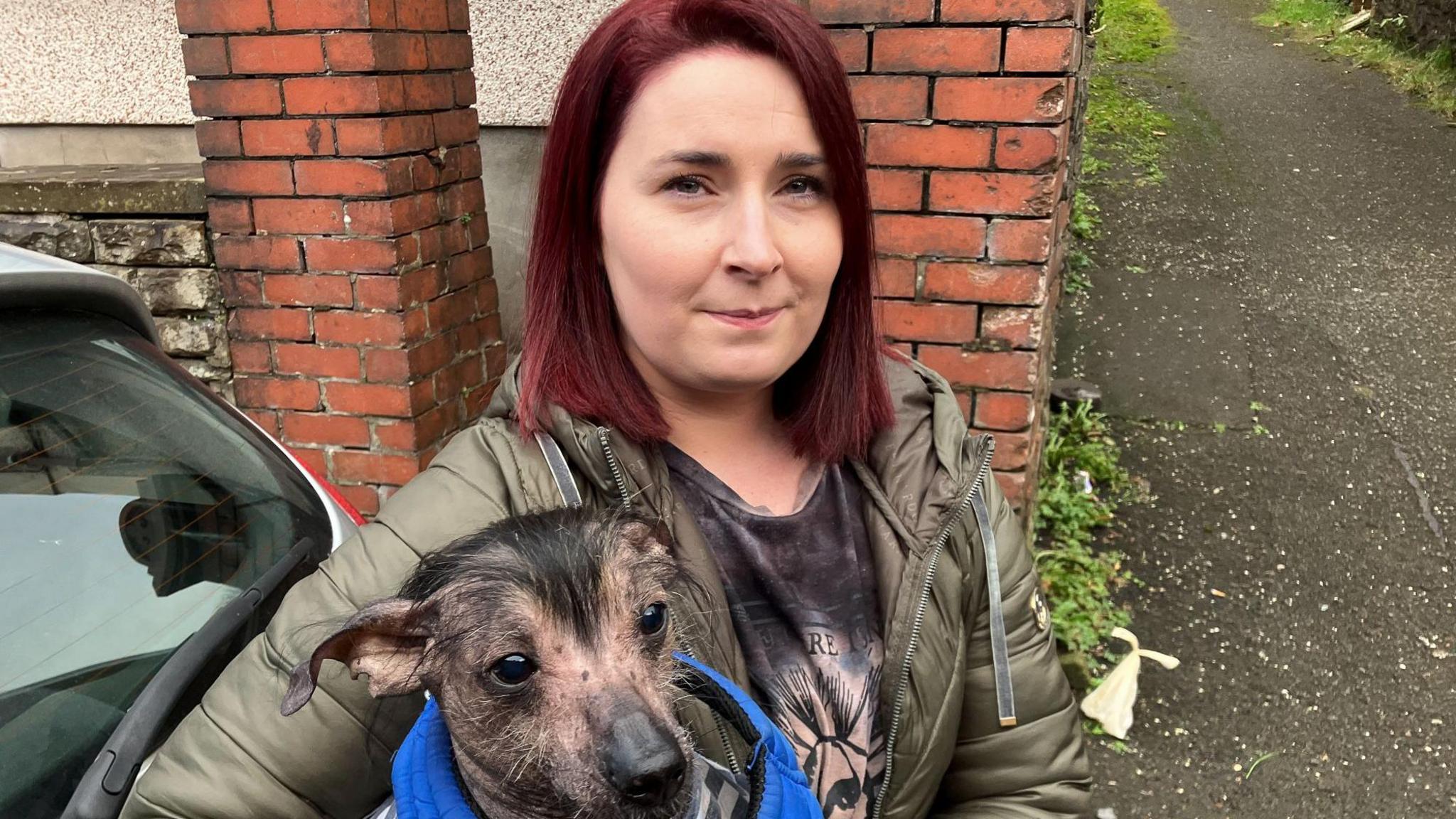 Katie Roberts on the street holding her dog