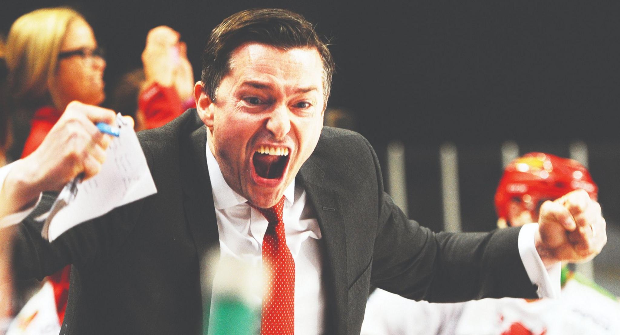 An animated Neil Francis shouts and punches the air on the bench at the end of a game