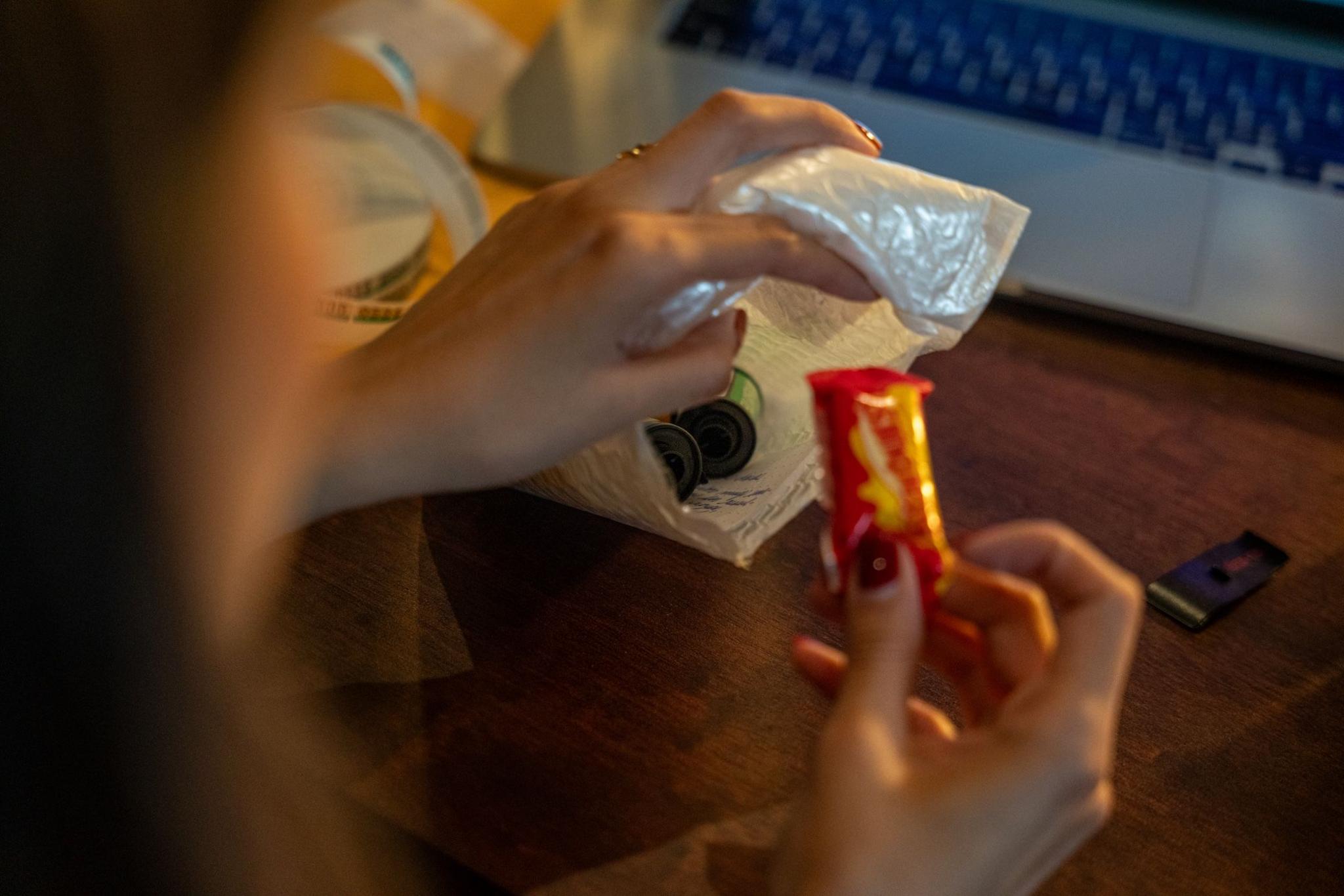 Sometimes clients who send in their film rolls also send sweets an little notes. Lucia holds up one of the sweets that came in one of the small packages sent by client. 