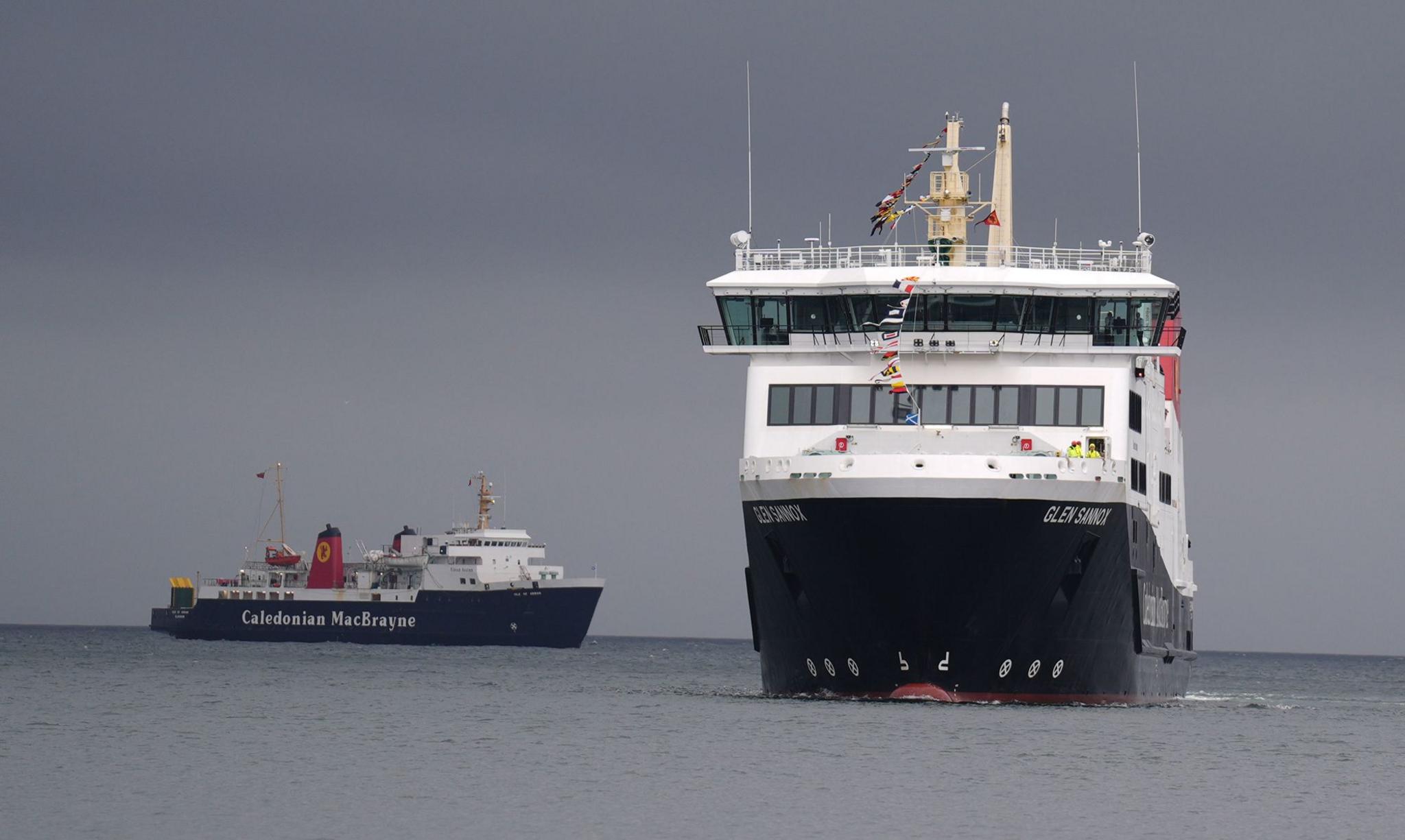 A small black and white ferry and a much larger newer ship, pictured heading towards the camera.