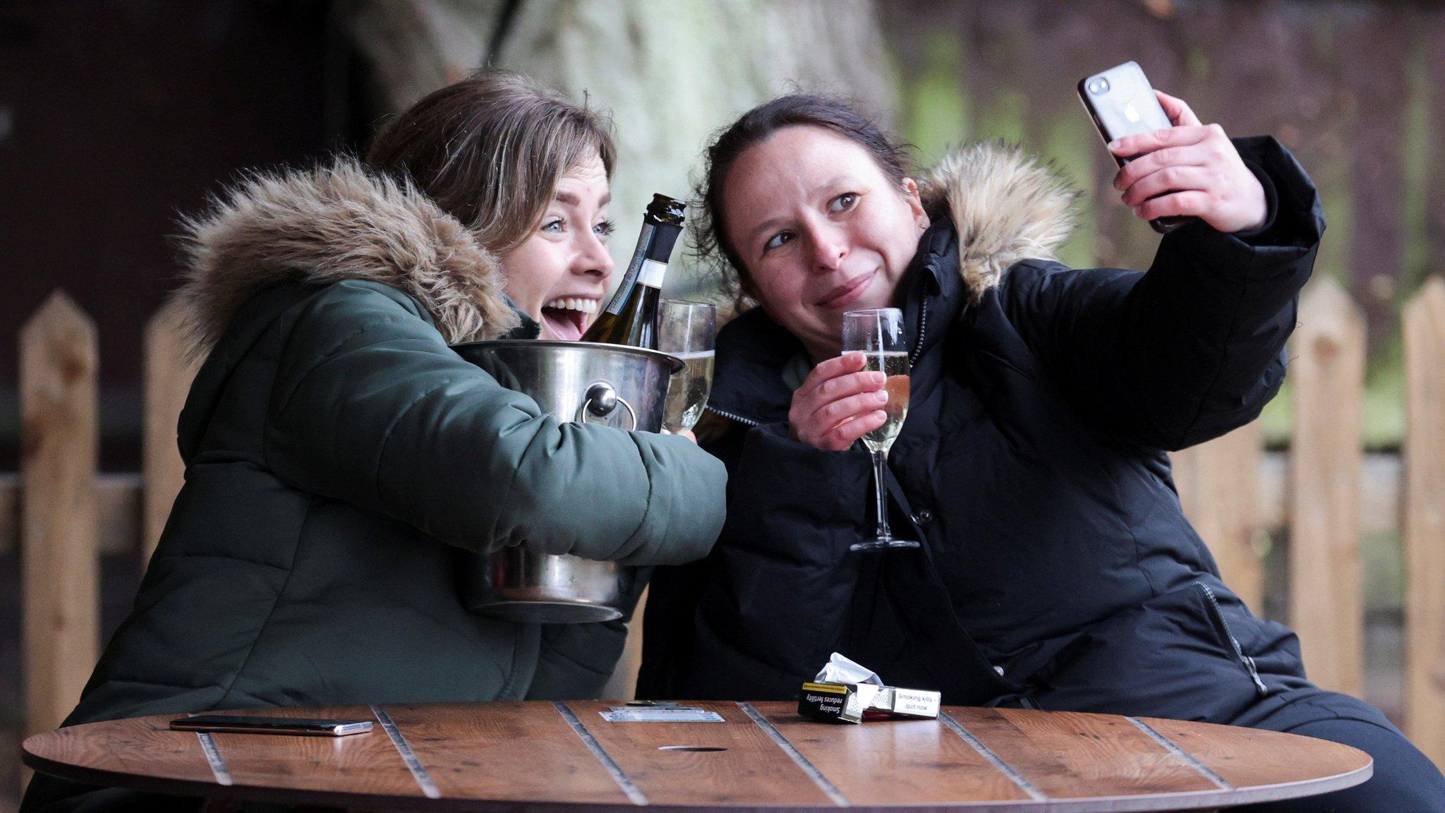 Women take a selfie with their drinks at The Fox on the Hill pub after its reopening, as the coronavirus restrictions ease, in London