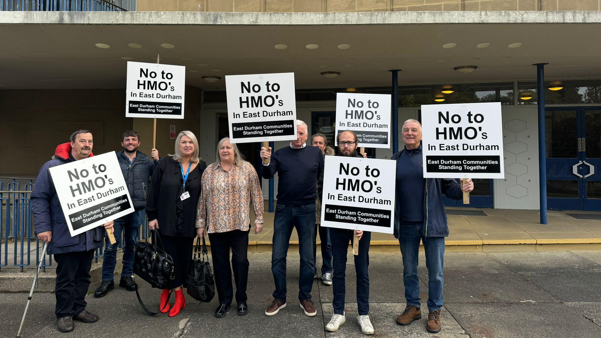 Eight members of East Durham Communities Standing Together group standing outside Durham County Hall and holding signs which read No to HMO's in East Durham.