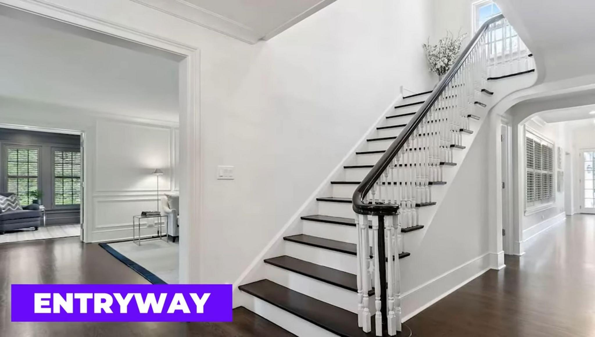 A modern white and black staircase in a hallway.