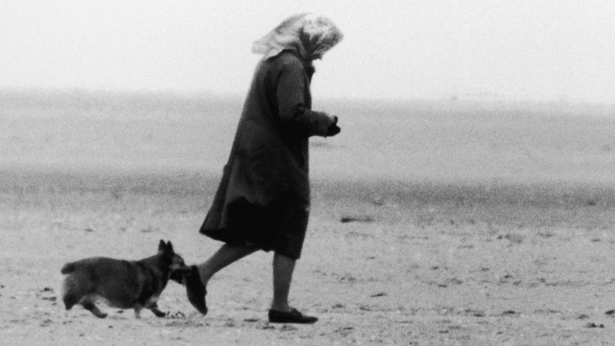 Queen Elizabeth II walking two of her corgis on Holkham beach near Sandringham in 1984