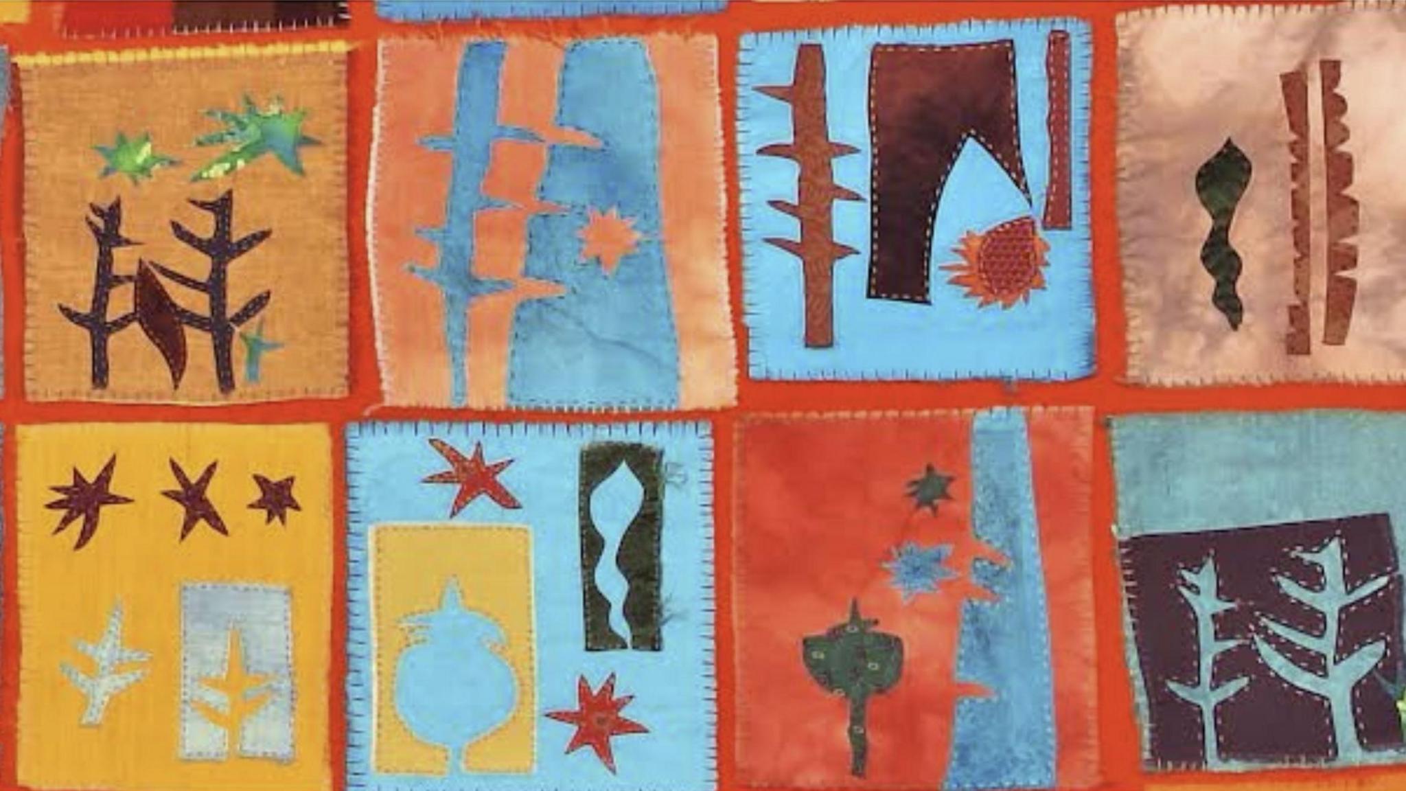 A series of images on fabric squares, sewn onto a canvas. They show trees and stars. The fabric squares are arranged in a patchwork of blue, yellow, orange, red and brown.