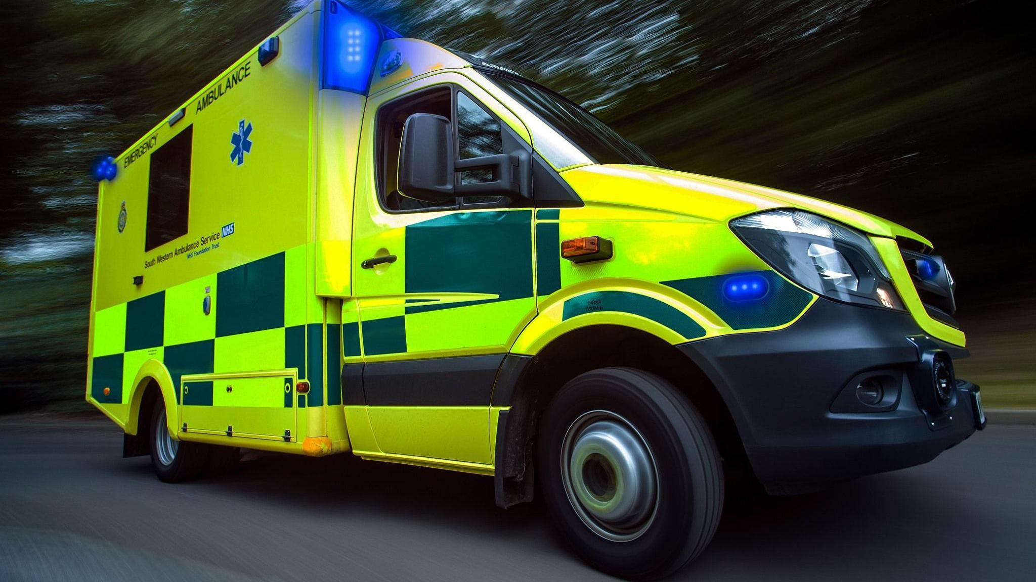 An ambulance from South Western Ambulance Service with flashing blue lights.