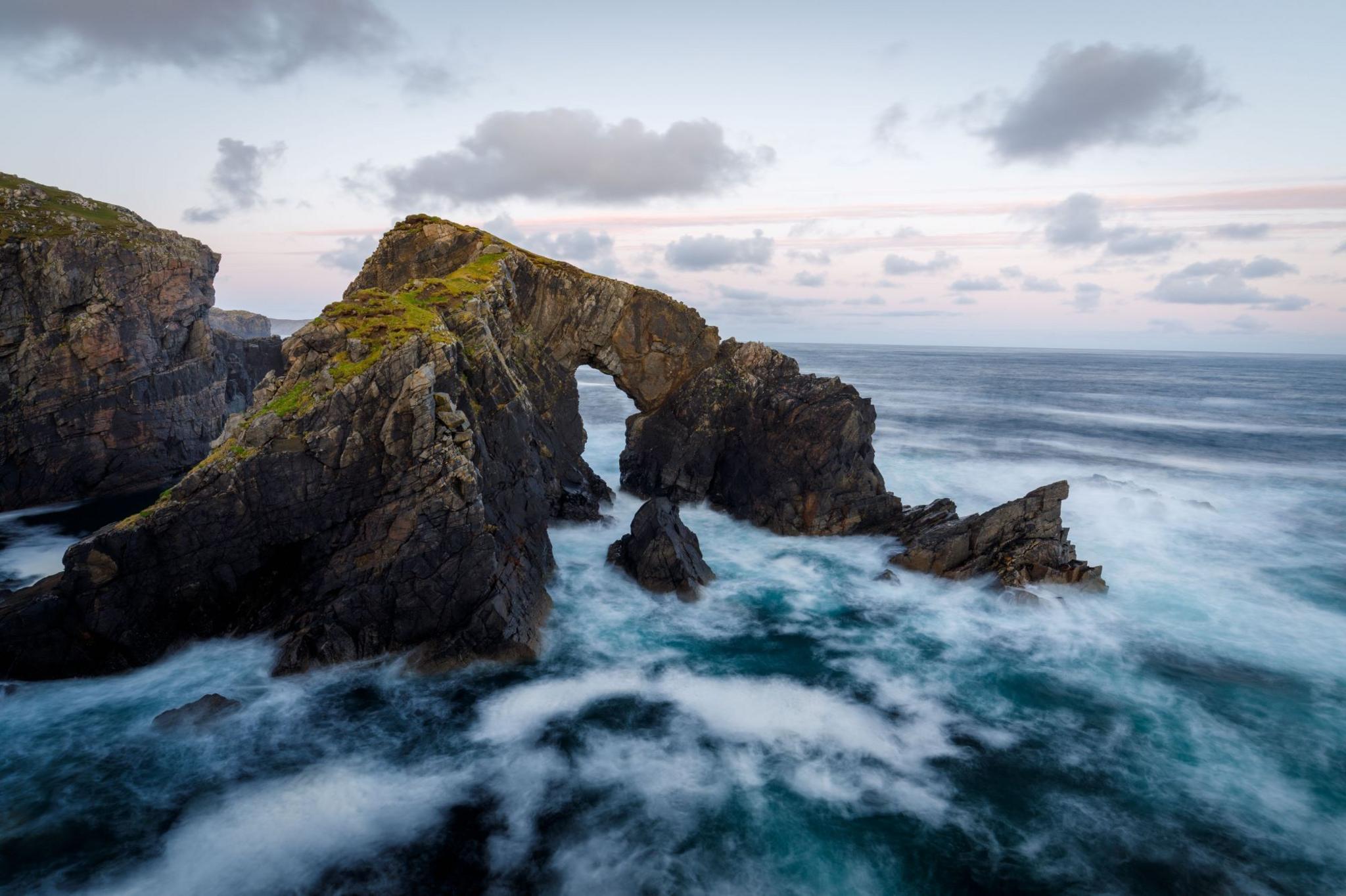 The sea arch of Stac a' Phris, pictured in a stormy sea