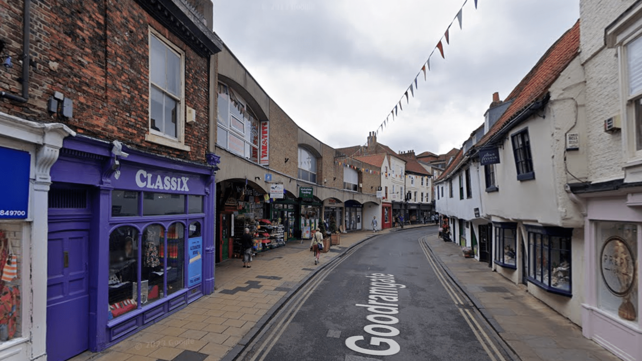 Goodramgate with shops on the left and right hand side, with a road going down the middle with double yellow lines on each side. 