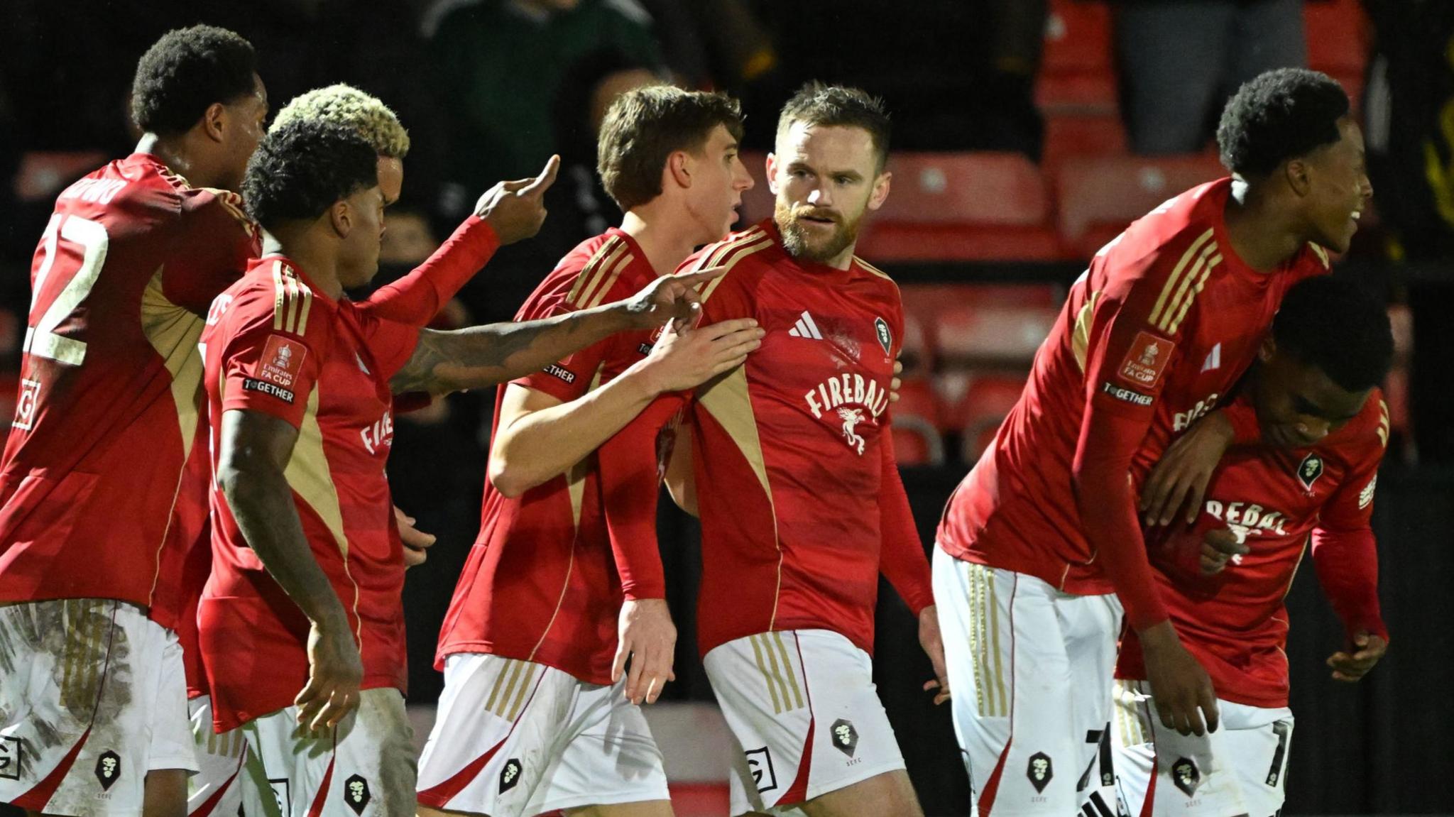 Salford City players celebrate Kelly N'Mai's second goal against Leyton Orient