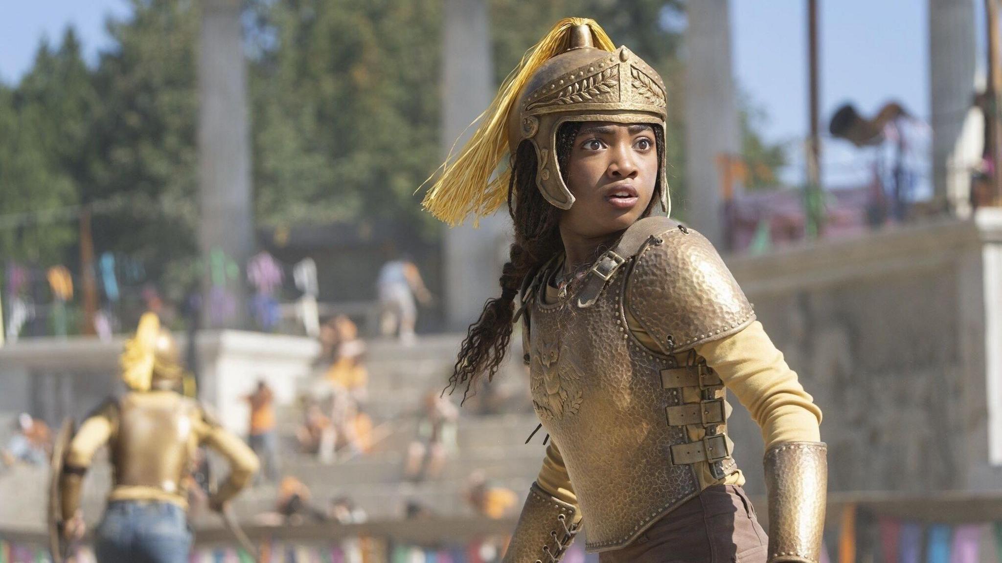 Leah Sava Jeffries wearing golden armour, looking confused and alarmed.