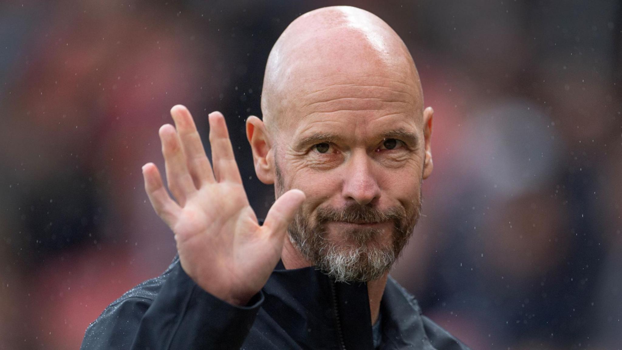 Erik ten Hag waves at a match