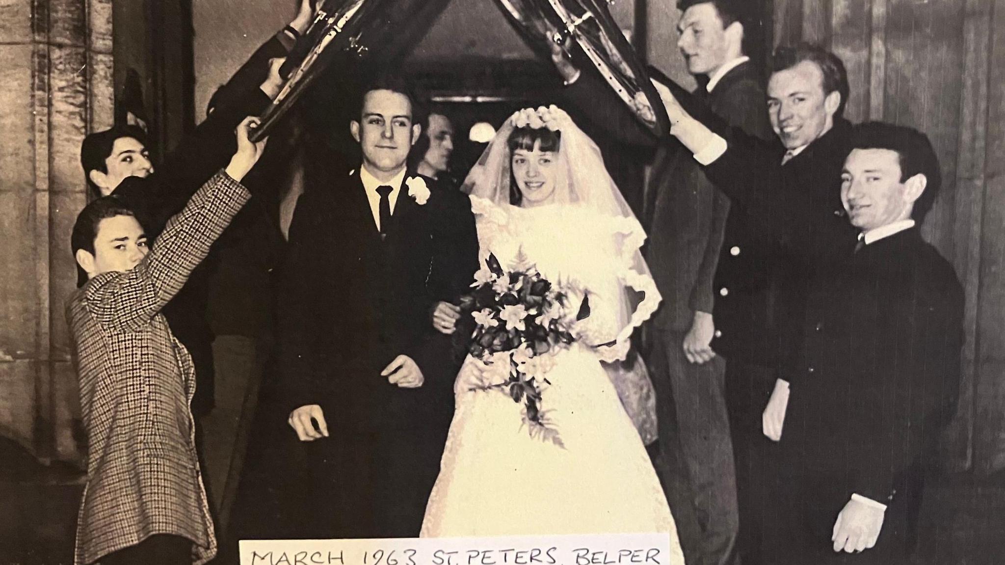 Richard and Pat Clark stood outside a church on their wedding day. 