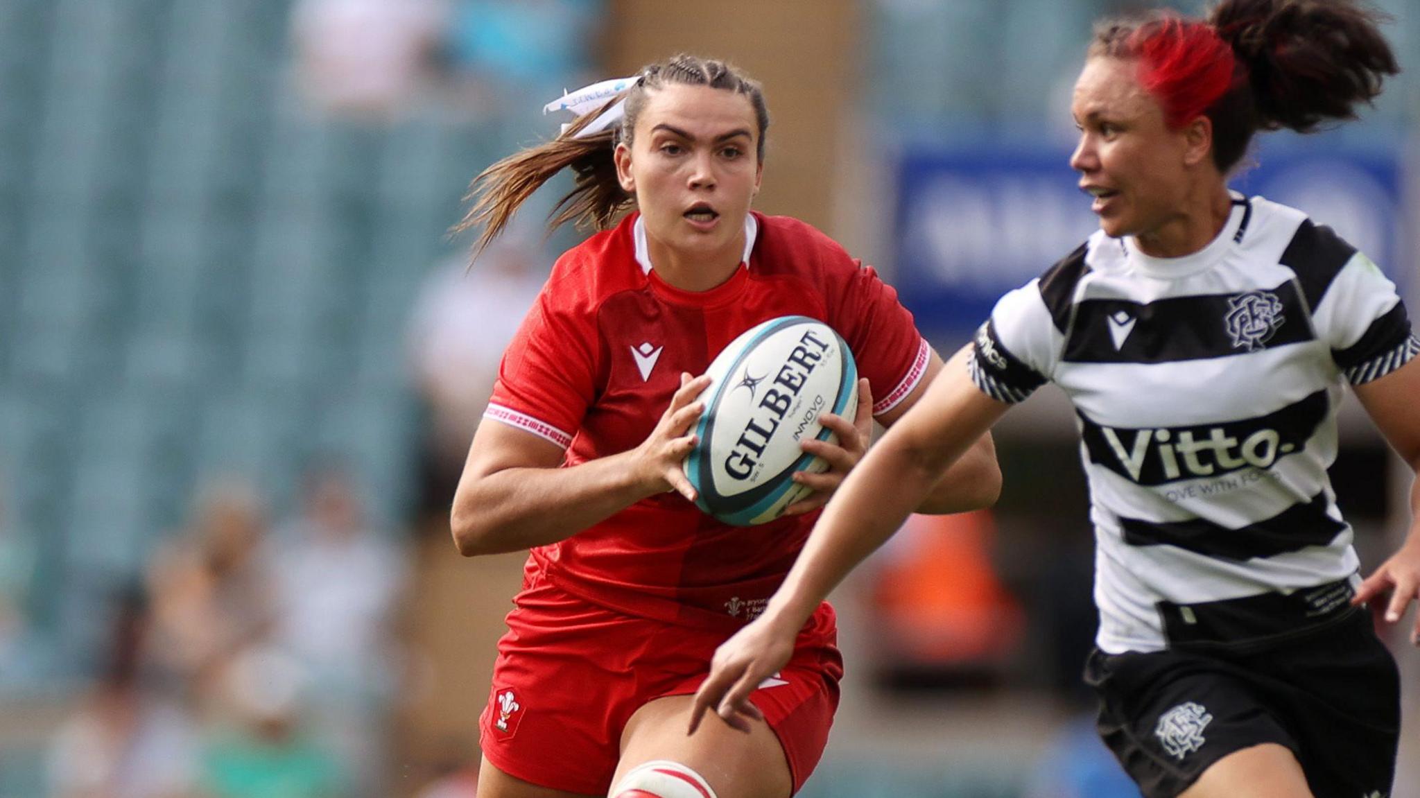 Wales number eight Bryonie King runs with the ball at Barbarians wing Ruby Tui