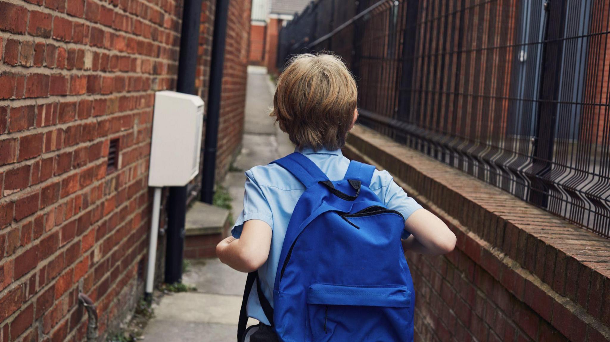 A child walking next to a school building