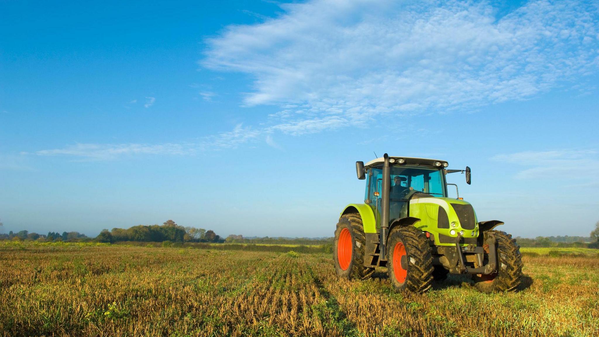 A farmer driving a tractor in the UK. 