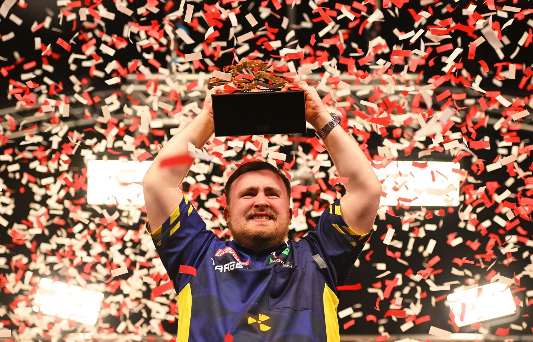 Luke Littler celebrates with the 2025 Ladbrokes UK Open Trophy at Butlins Holiday Centre in Minehead, England