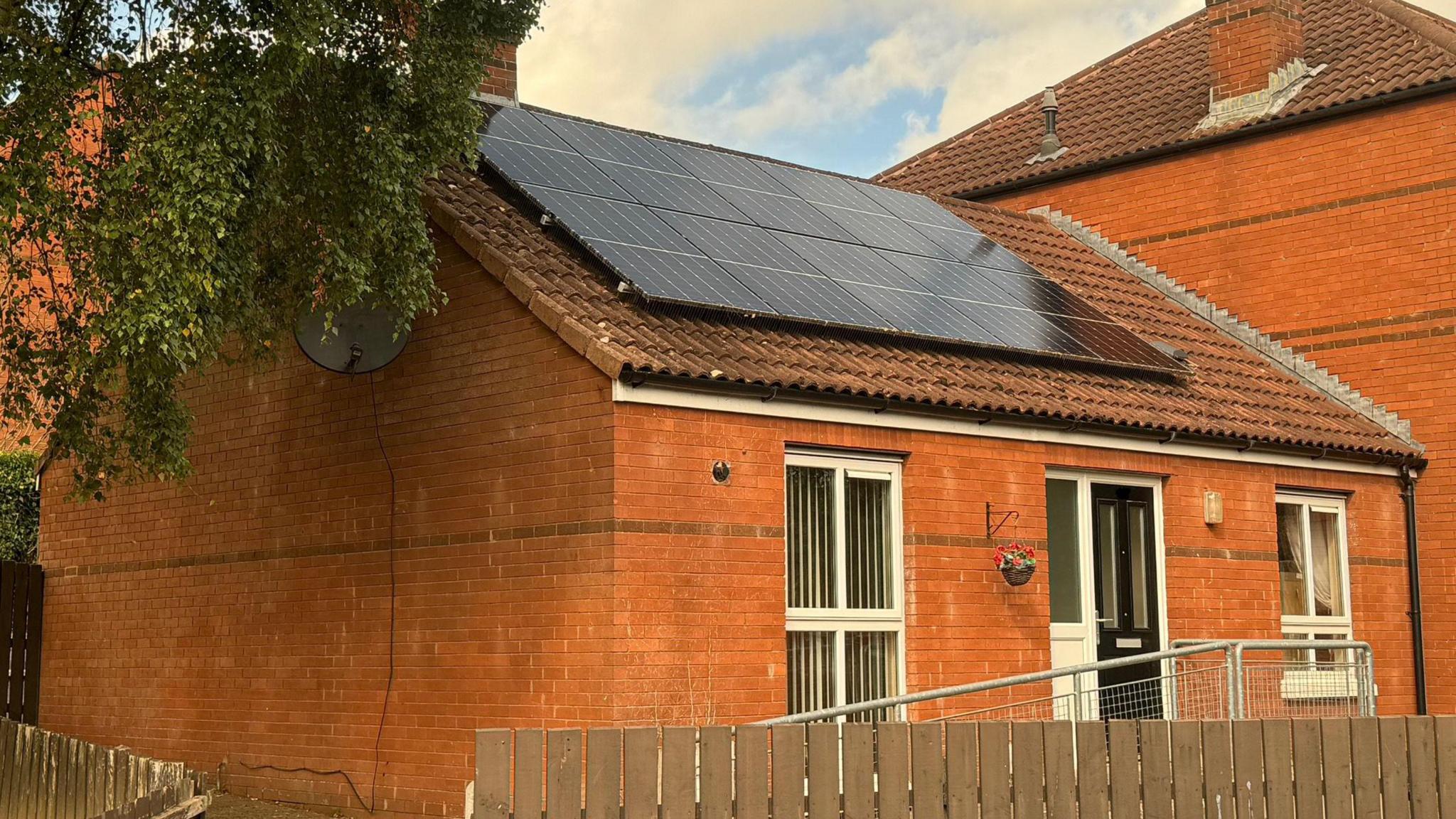 A red brick house with solar panels on the roof