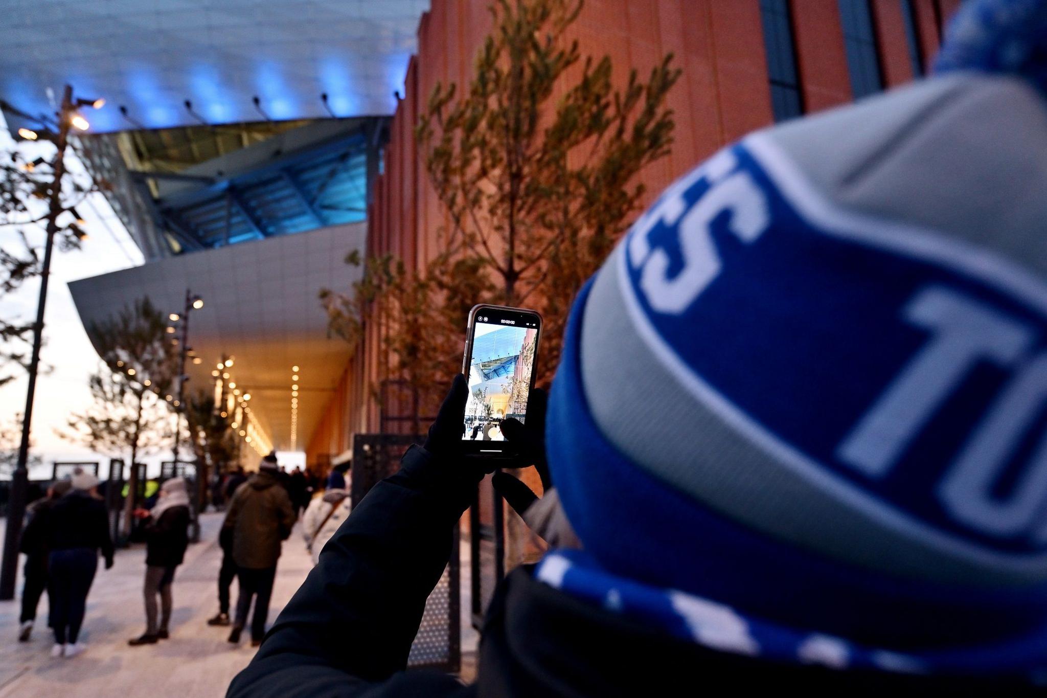 An Everton fan taking a photo of the stadium