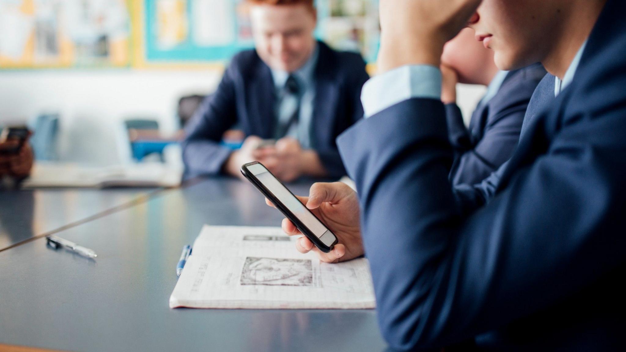 Male student using phone during a class
