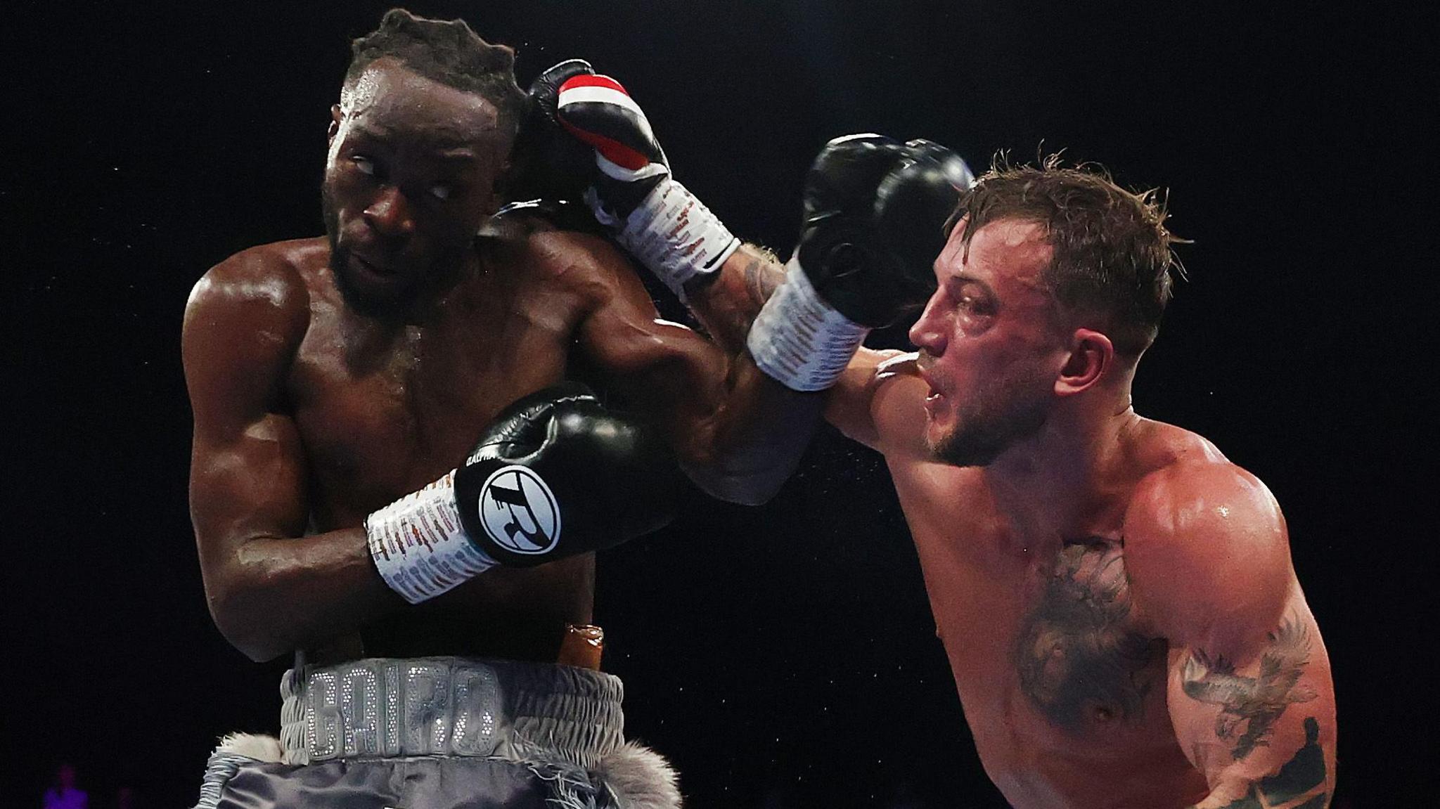 Brad Pauls fights against Denzel Bentley. His right hand is making contact with Bentley's head, while Bentley is throwing a left jab.