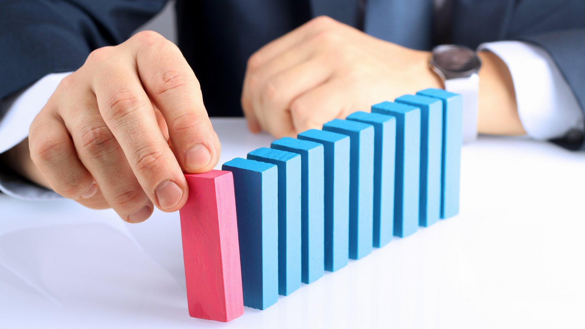 Businessman pushing wooden block