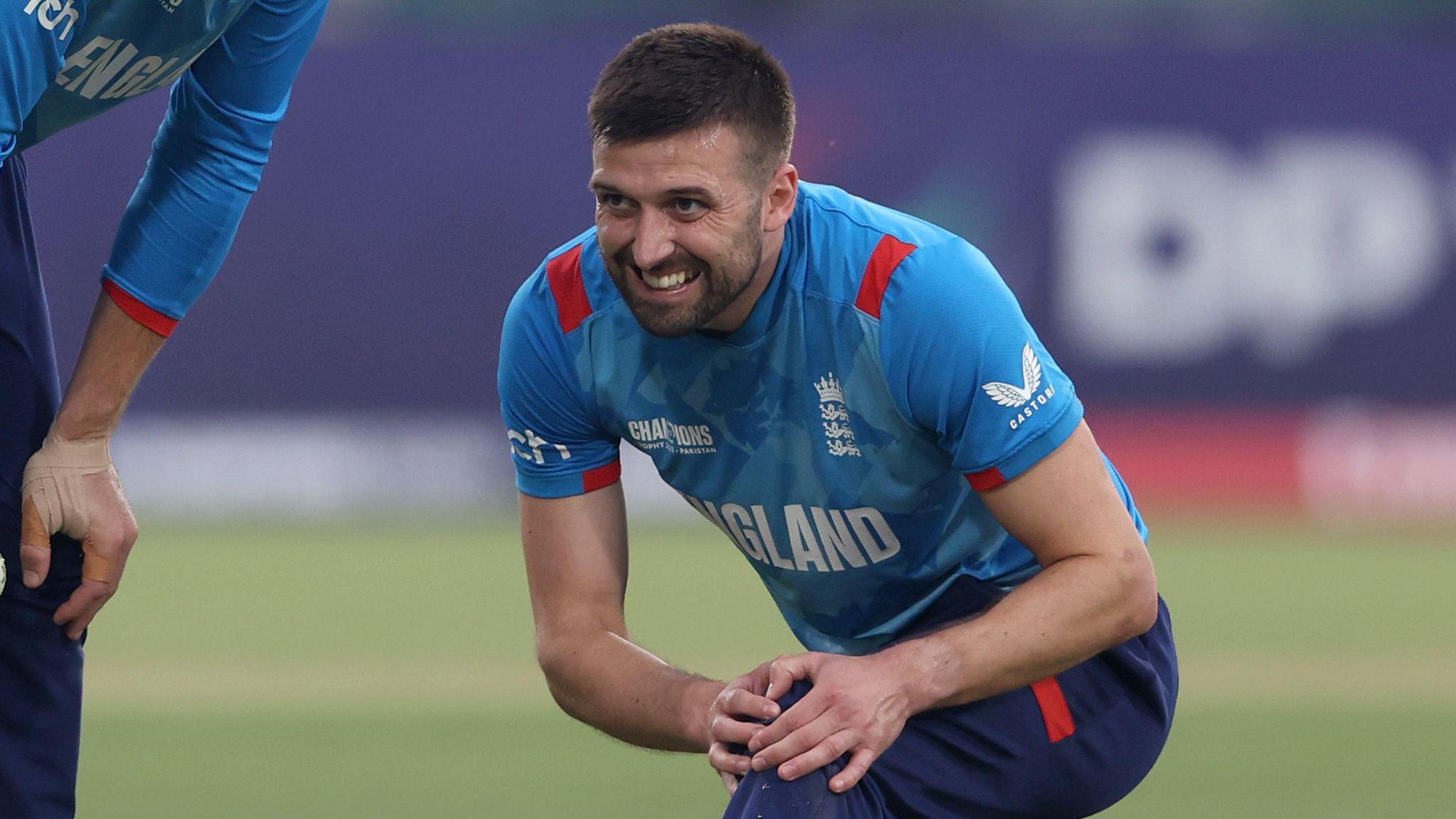 England fast bowler Mark Wood grimaces as he holds his left knee