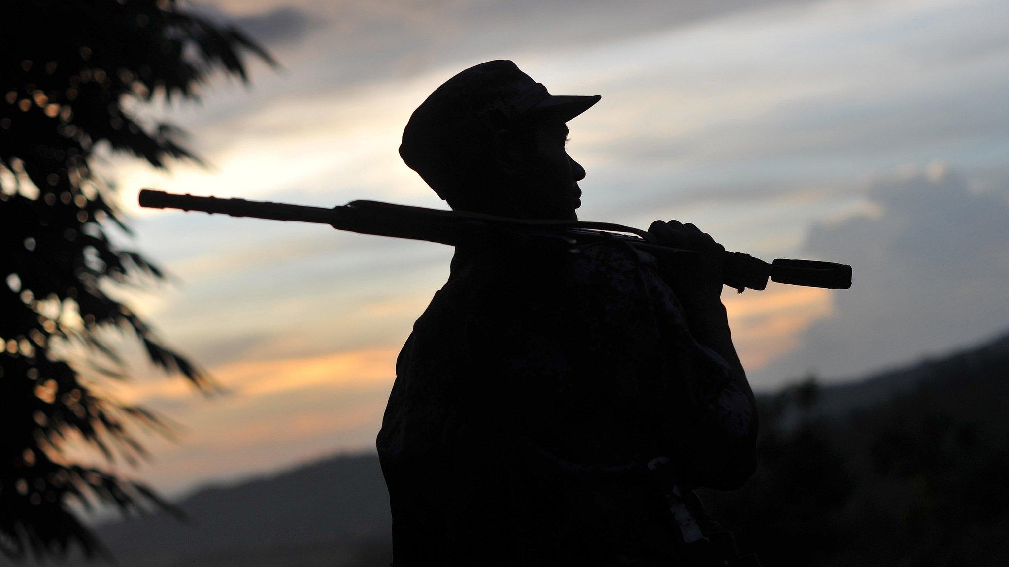 A soldier from the All Burma Students Democratic Front - Northern Burma (ABSDF-NB), an ally of the Kachin Independence Army (KIA) holding his weapon as he looks out from an outpost on the Laja Yang frontline