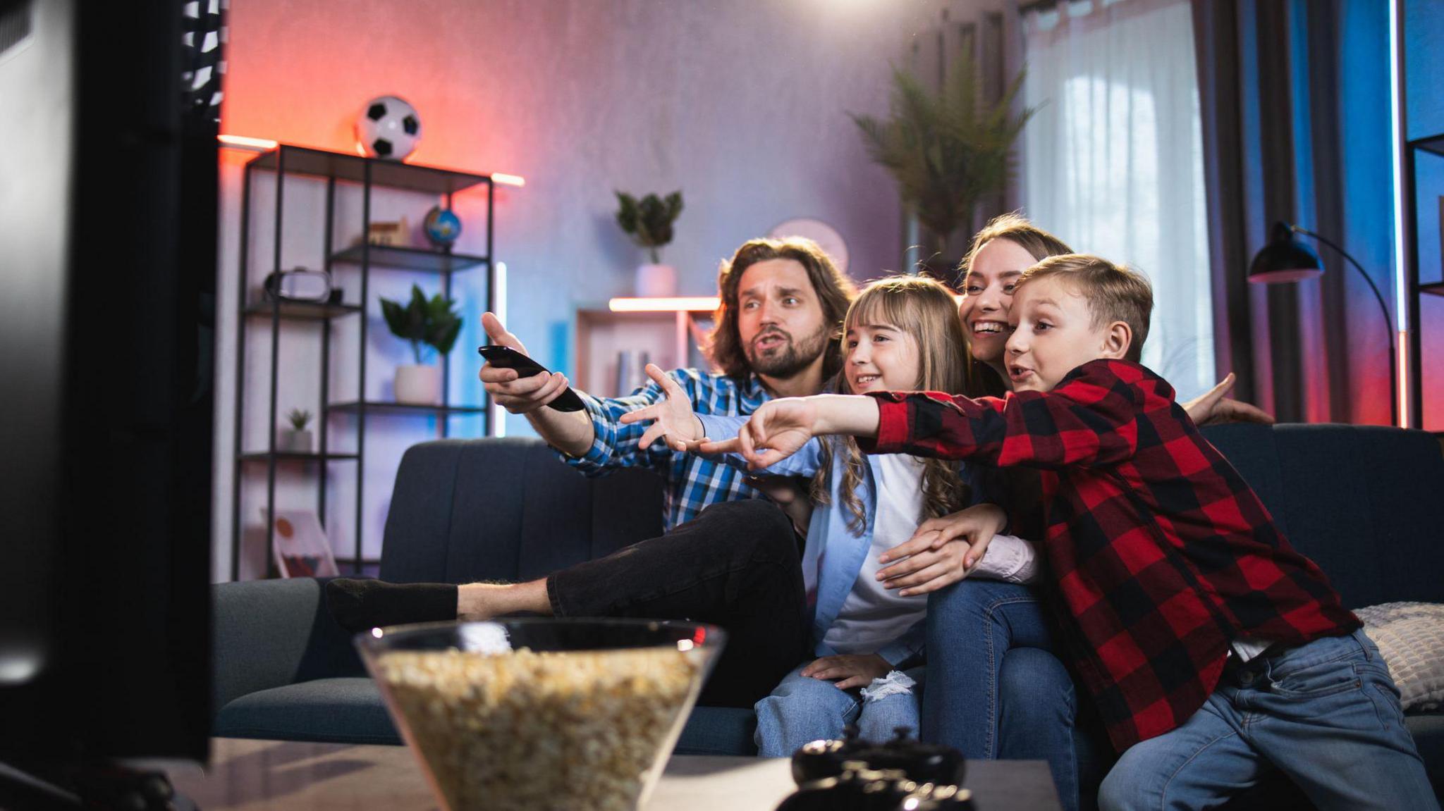 Family with popcorn watching TV