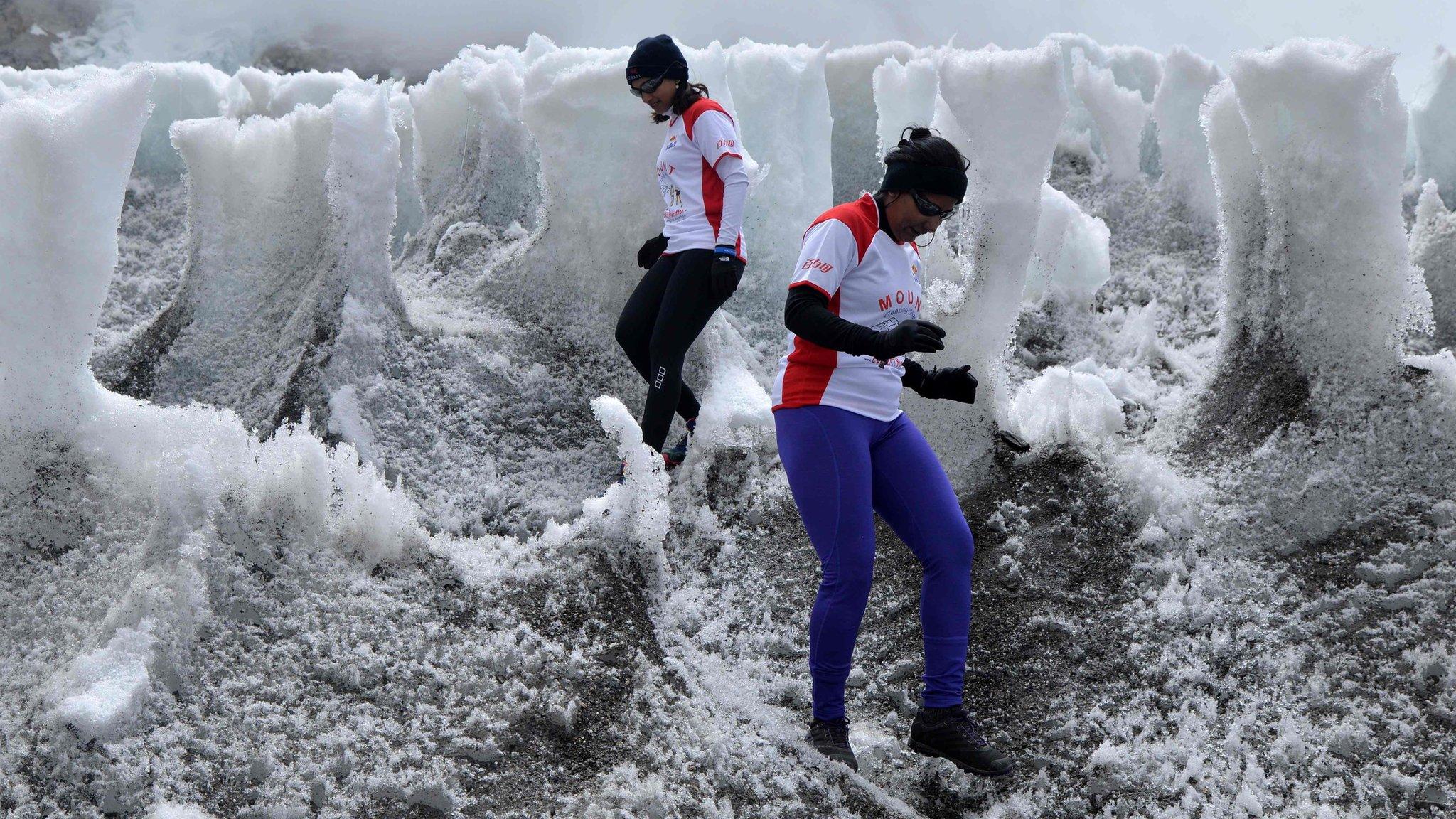 In this handout photograph released by Himex, the marathon's organisers, two runners weave between blocks of ice and snow as they participate in the world's highest marathon on 29 May 2016.