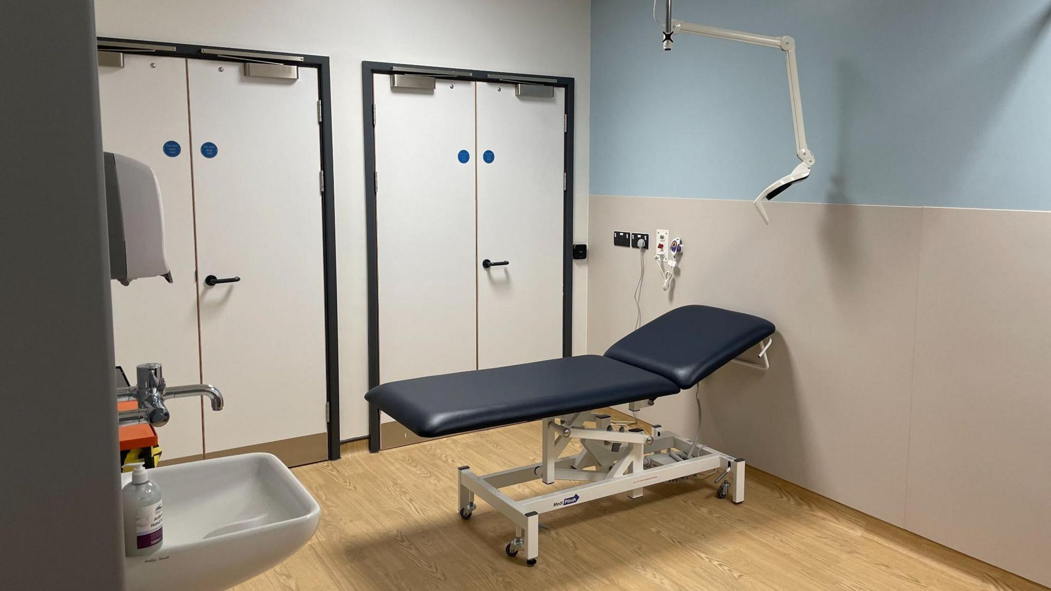 One of the consultation rooms. There is a patient chair near a sink.