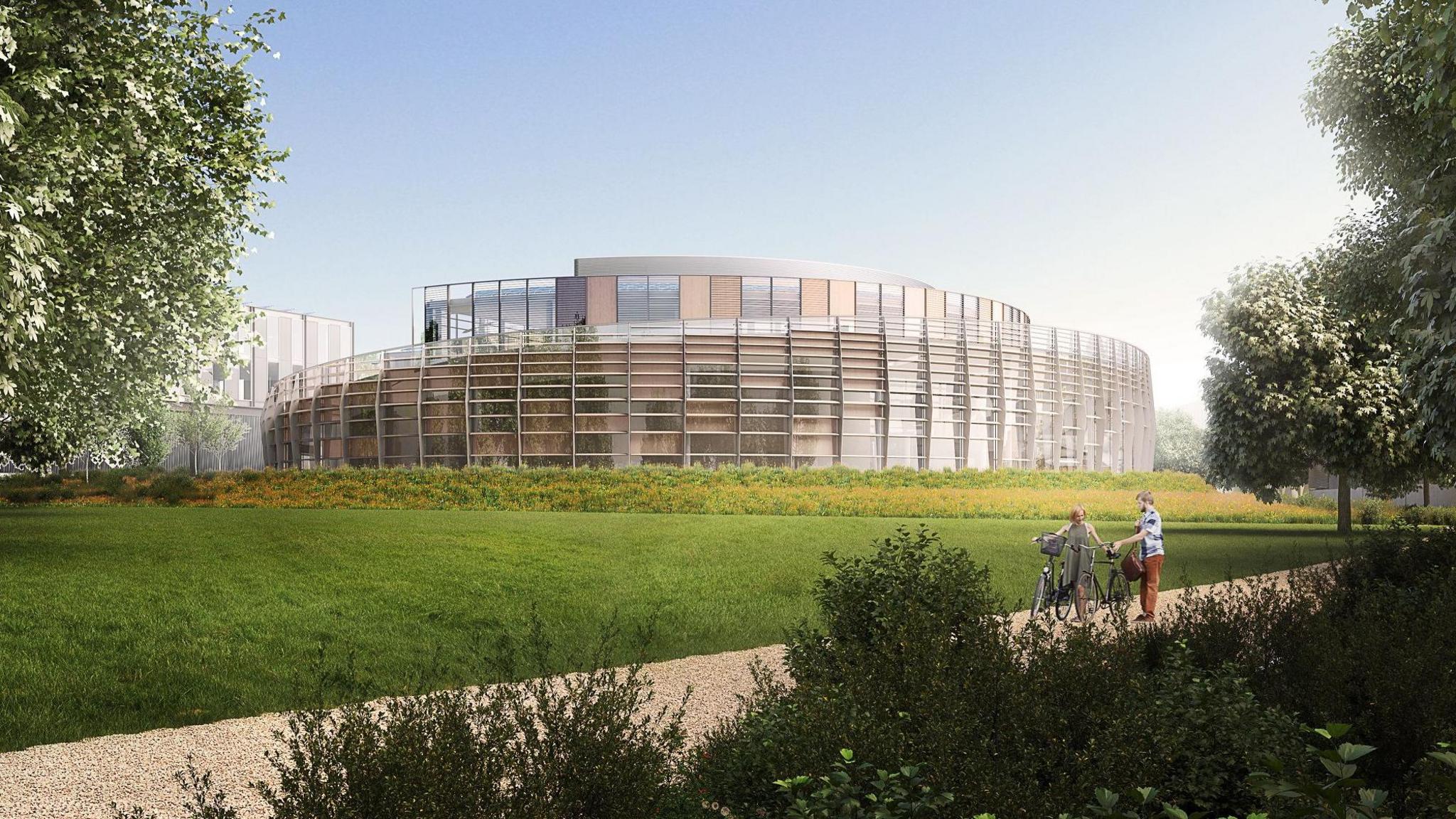 An artistic impression of what one of the buildings at Marlow Film Studios could look like, a reflective modern building surrounded by trees, greenery and a cycle path.