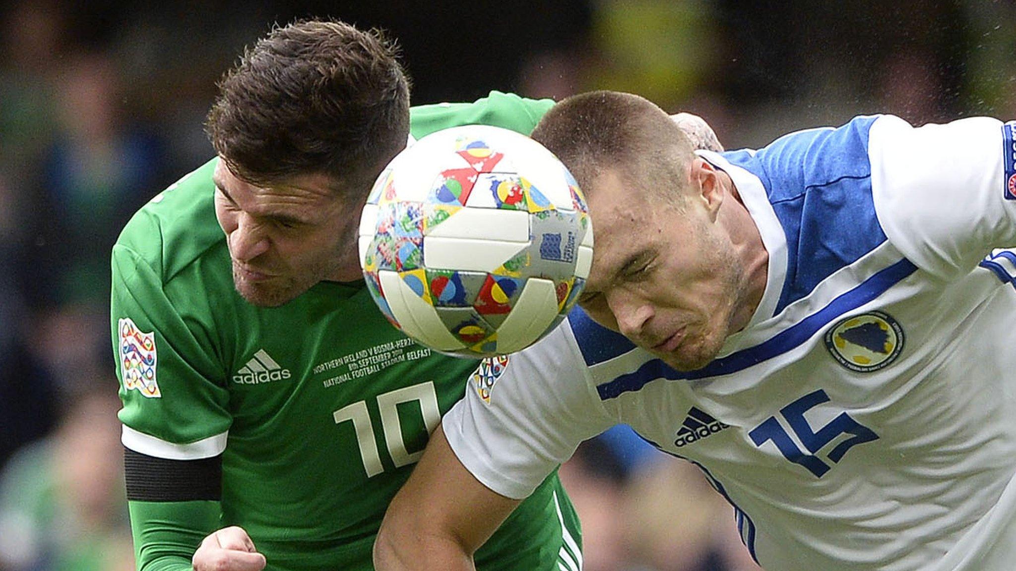 Northern Ireland striker Kyle Lafferty competes against Toni Sunjic of Bosnia-Herzegovina