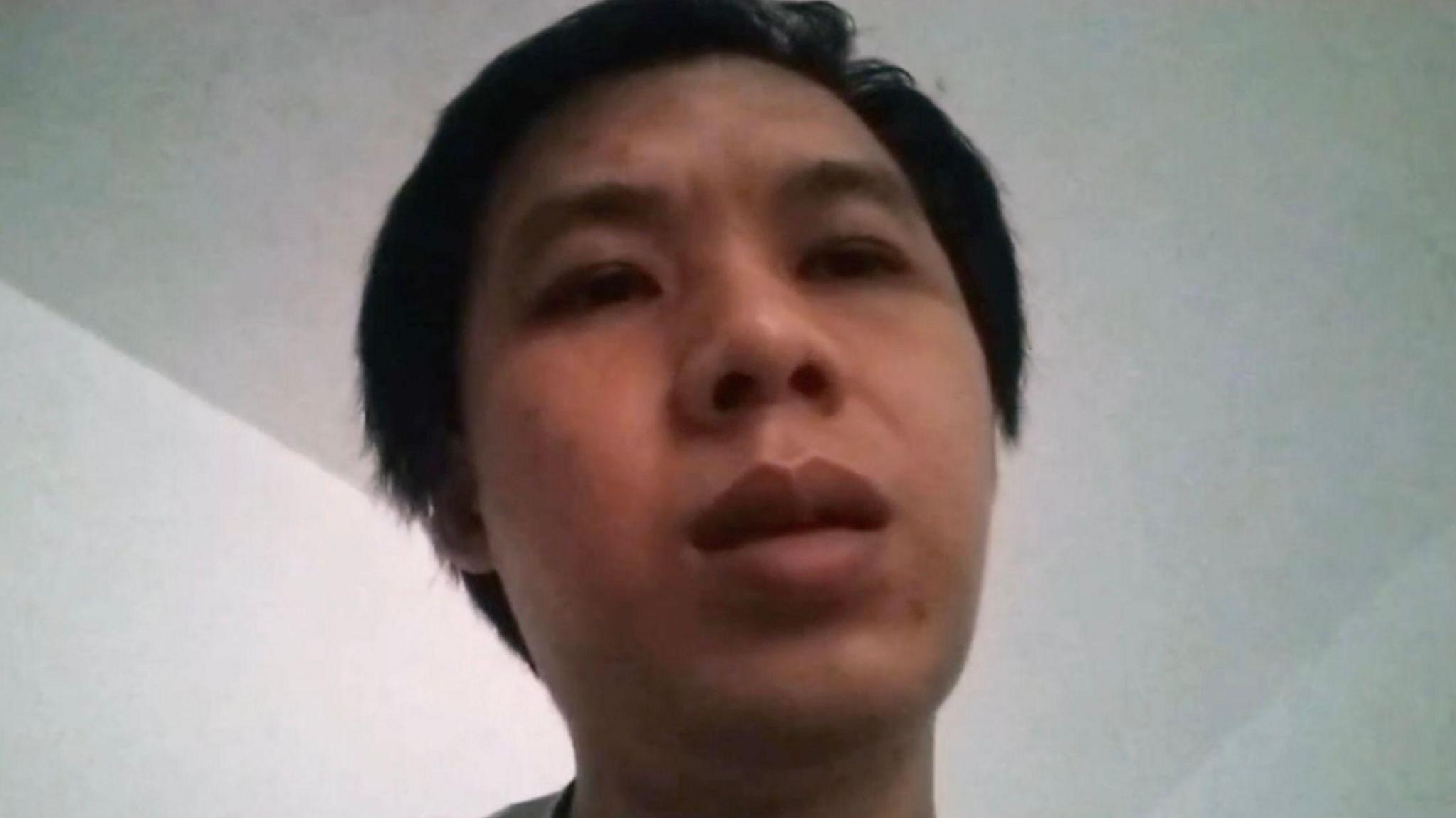 A grainy close-up photo of a man's face, his expression neutral